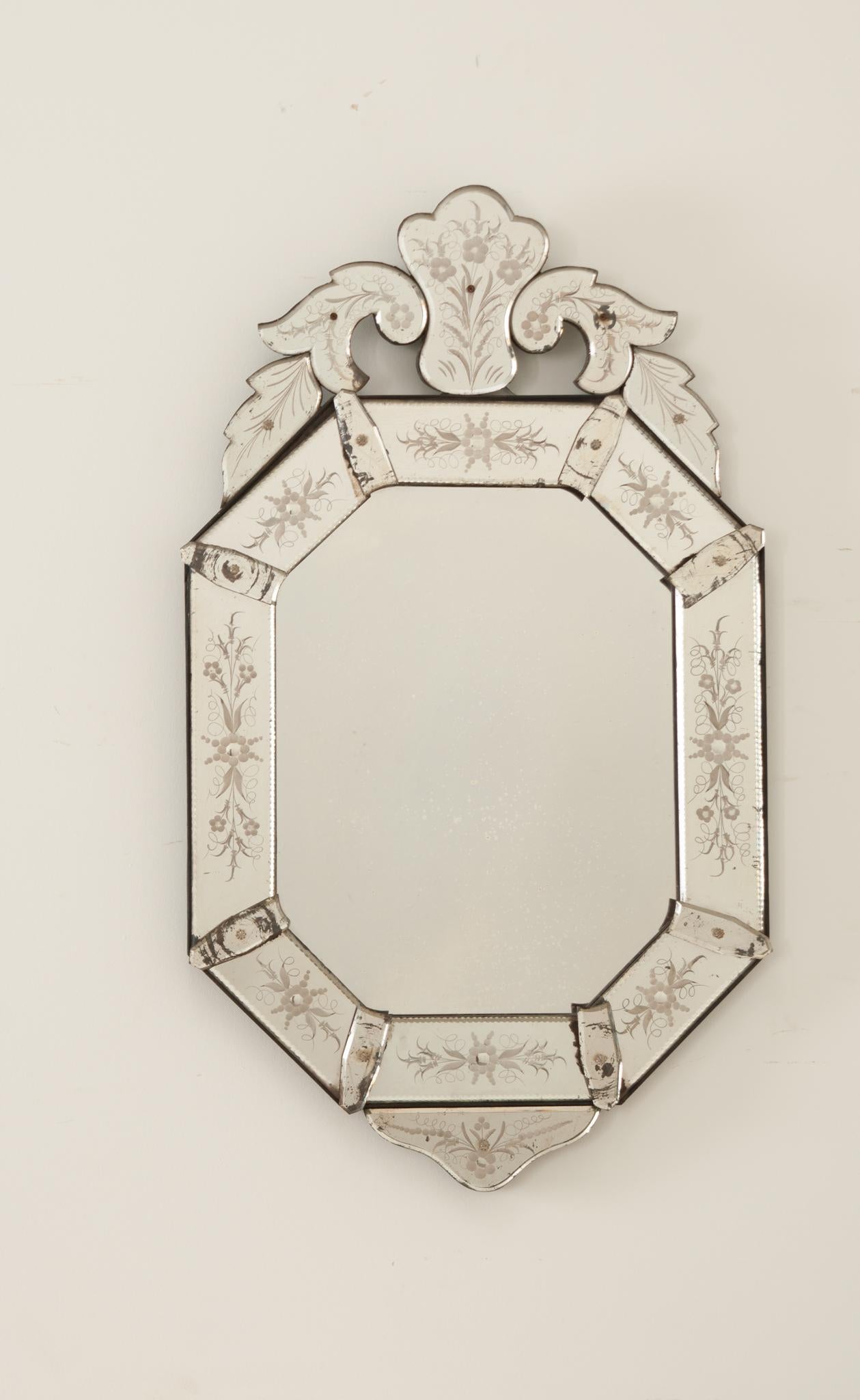 This darling octagonal Venetian mirror was handcrafted during the 19th century in Italy with old world charm in mind. This antique has beautifully shaped mirror pieces, held together with fasteners that are capped in crystal. Every aspect of the
