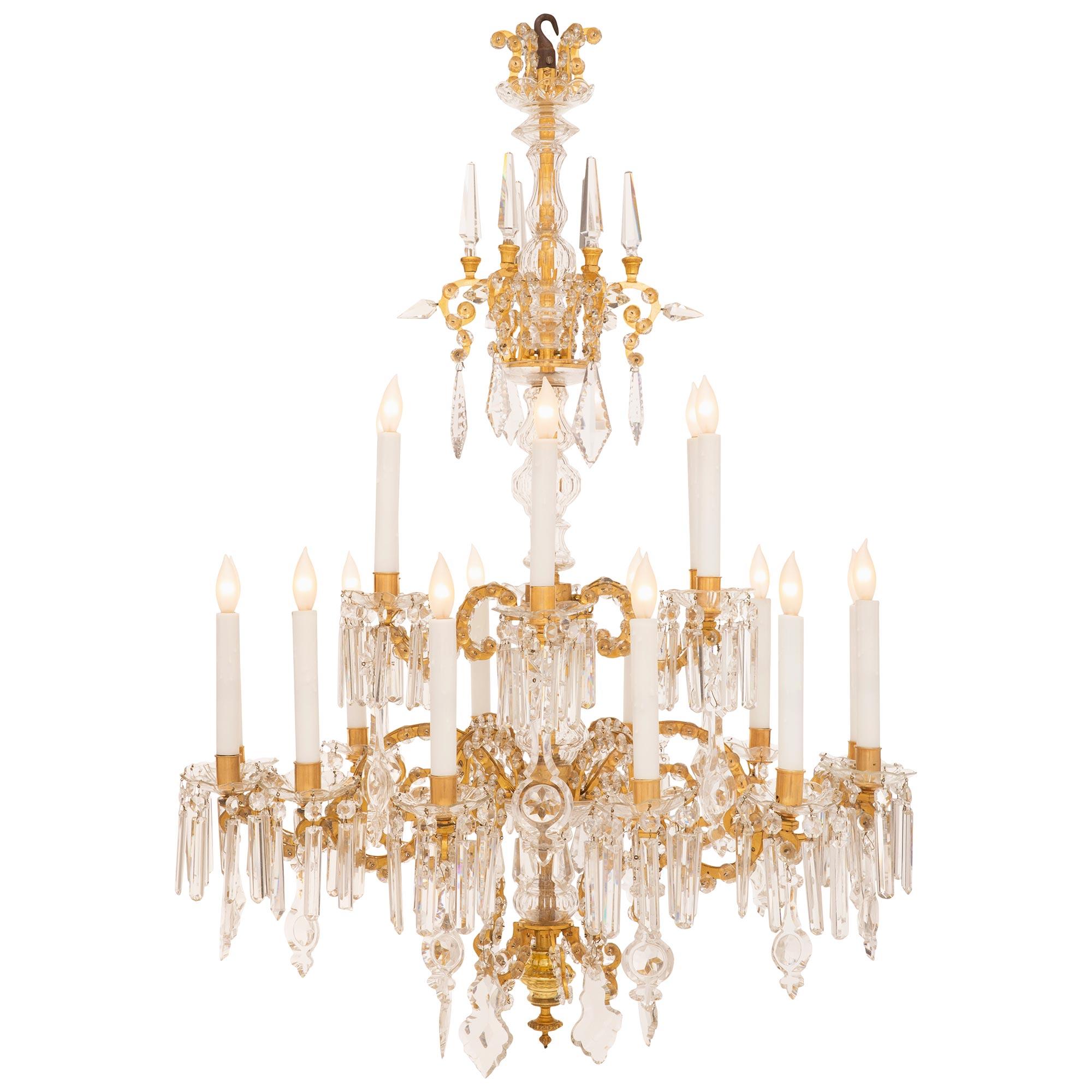 A stunning Italian 19th century Venetian st. ormolu and crystal chandelier. The eighteen arm two tier chandelier is centered by a bottom topie shaped finial below most decorative scrolled designs adorned with charming rosettes with the central fut