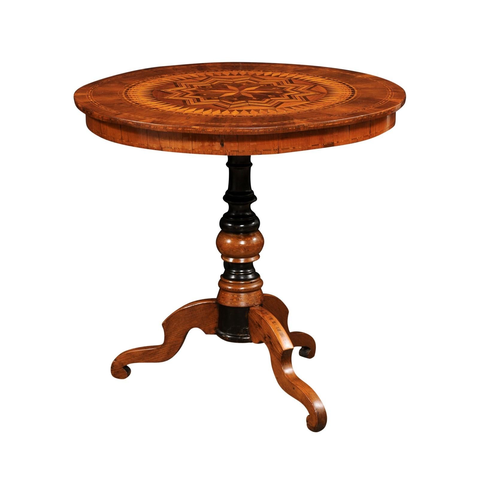 Italian 19th century marquetry walnut and birch center table with marquetry top, geometric motifs including radiating stars and diamonds. Exuding an air of timeless elegance, this Italian 19th century marquetry center table invites you to immerse