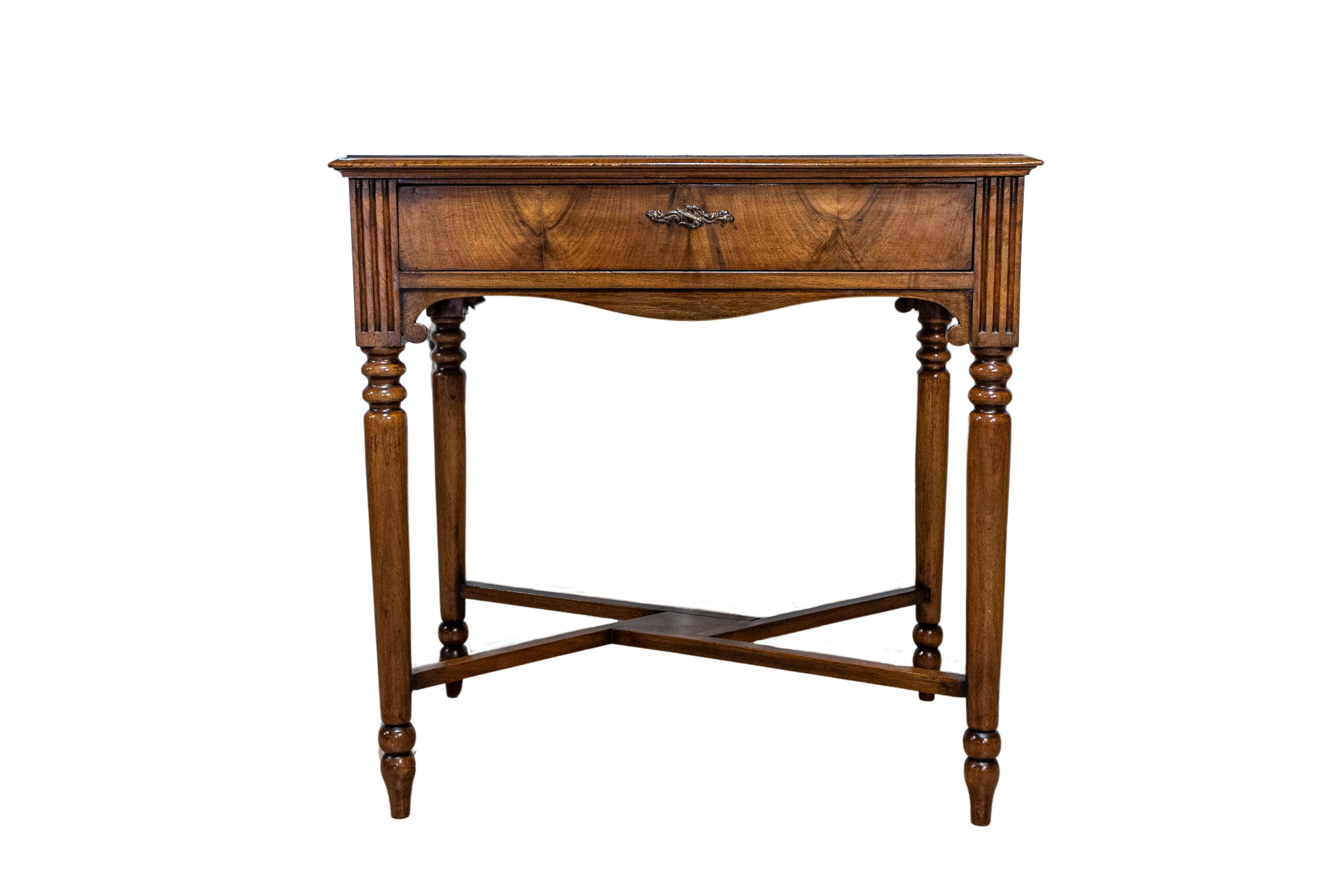 An Italian walnut and mahogany game table from the 19th century with marquetry checkerboard top partitioned drawer, fluted knees, cylindrical tapering legs and X-Form cross stretcher. This 19th-century Italian walnut and mahogany game table marries