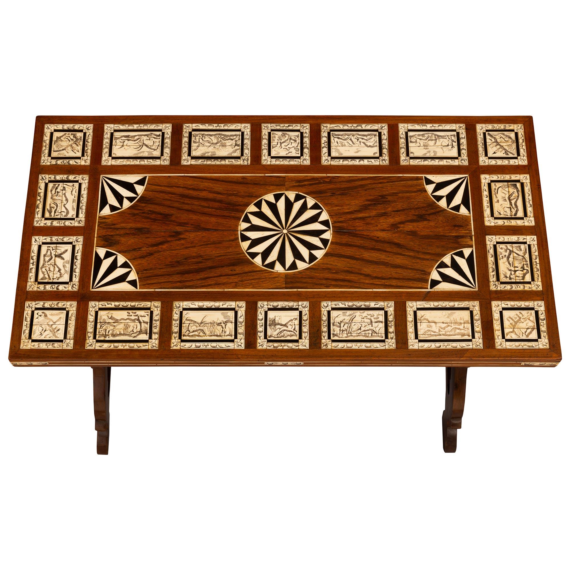 Une très belle table basse italienne du XIXe siècle en noyer, os et ébène. La table est surélevée par deux supports de tréteaux percés et inclinés, reliés par une civière en fer forgé tournée en spirale. Le sommet est joliment décoré de dix-huit