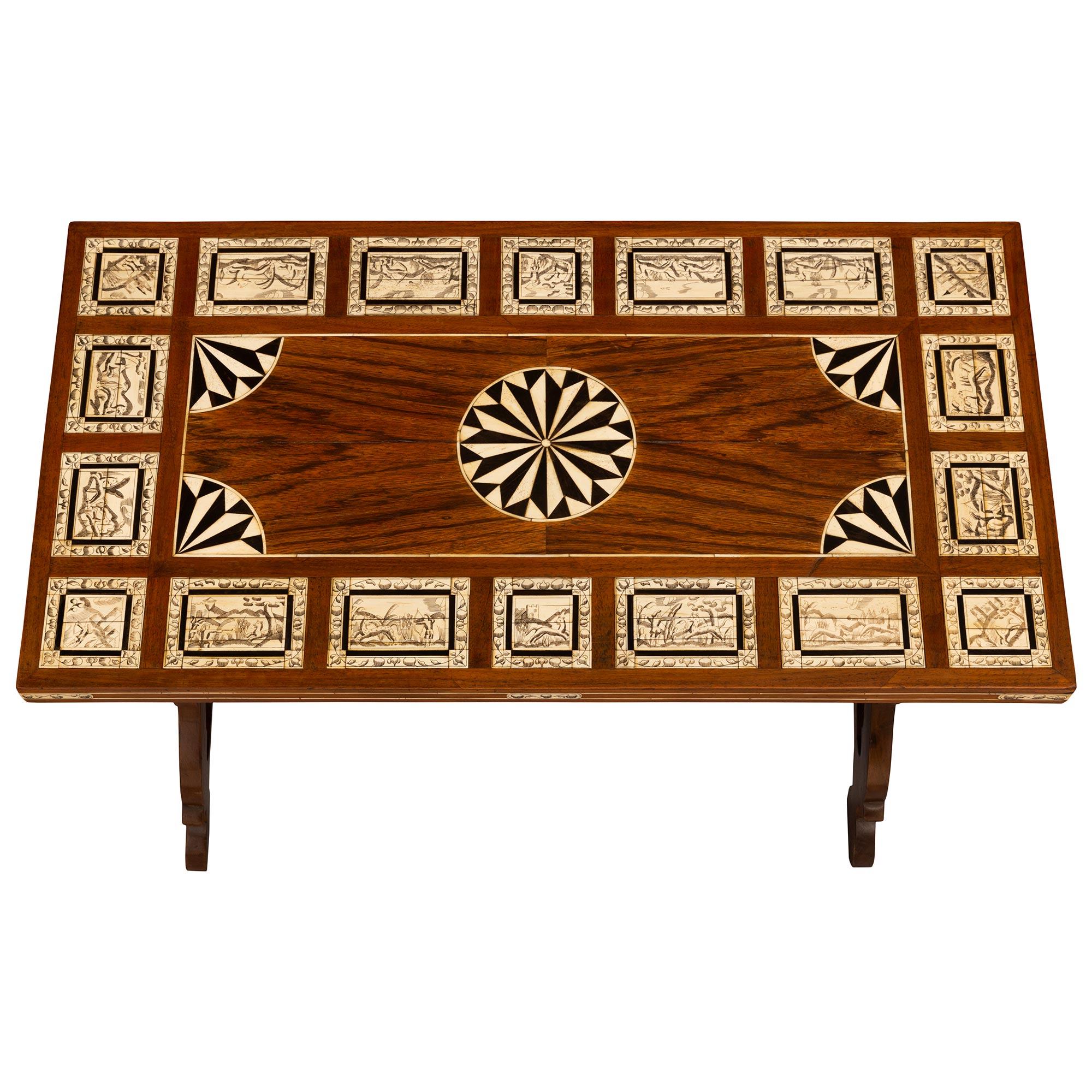 A very attractive Italian 19th century walnut, bone and ebony coffee table. The table is raised by two slanted pierced trestle supports joined by a spiral turned wrought iron stretcher. The top is handsomely decorated by eighteen rectangular and