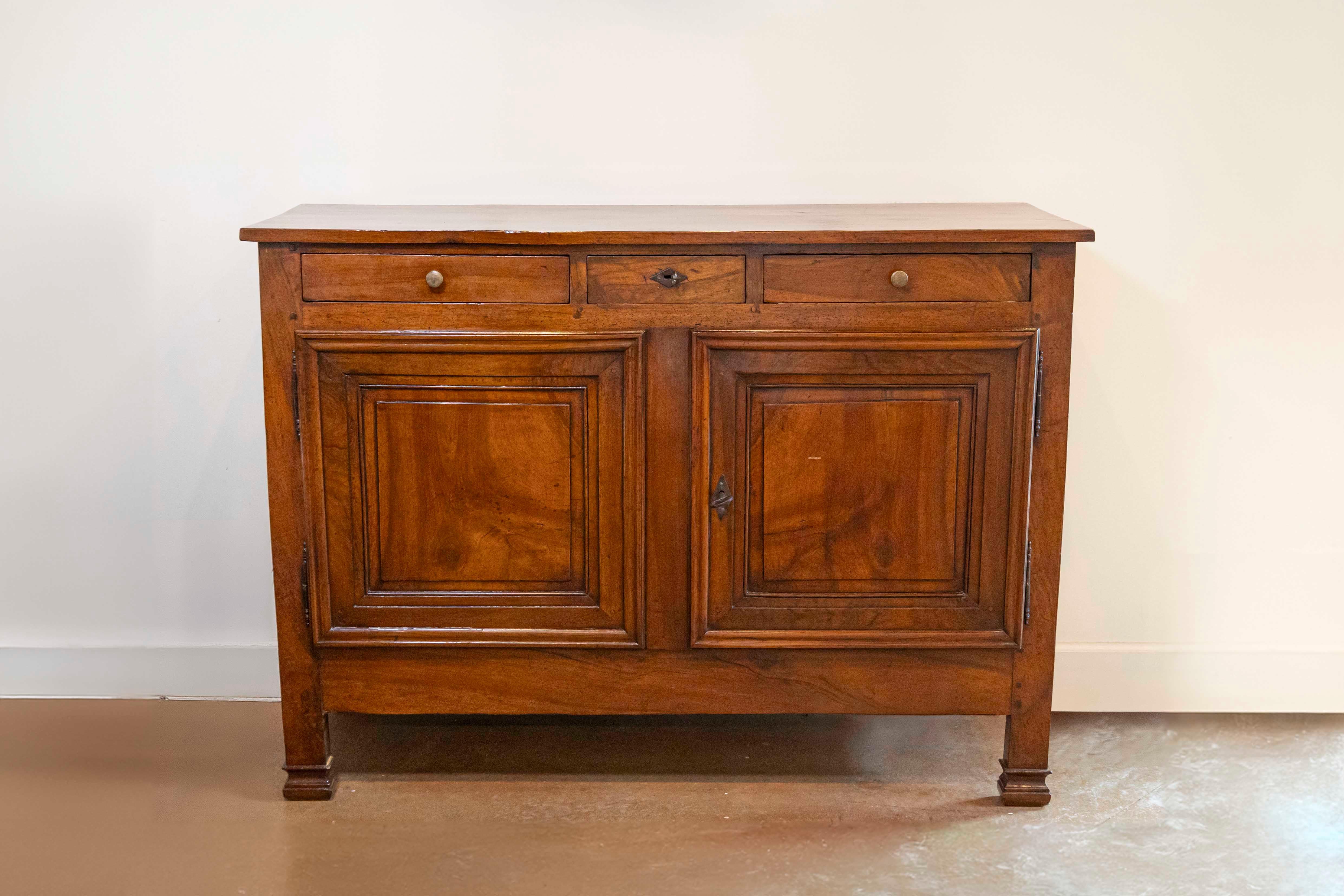 Un buffet italiano in noce del XIX secolo, con tre cassetti, una coppia di ante modellate e piedi anteriori delicatamente intagliati. Creato in Italia durante il XIX secolo, questo buffet in noce presenta un semplice piano rettangolare che si trova