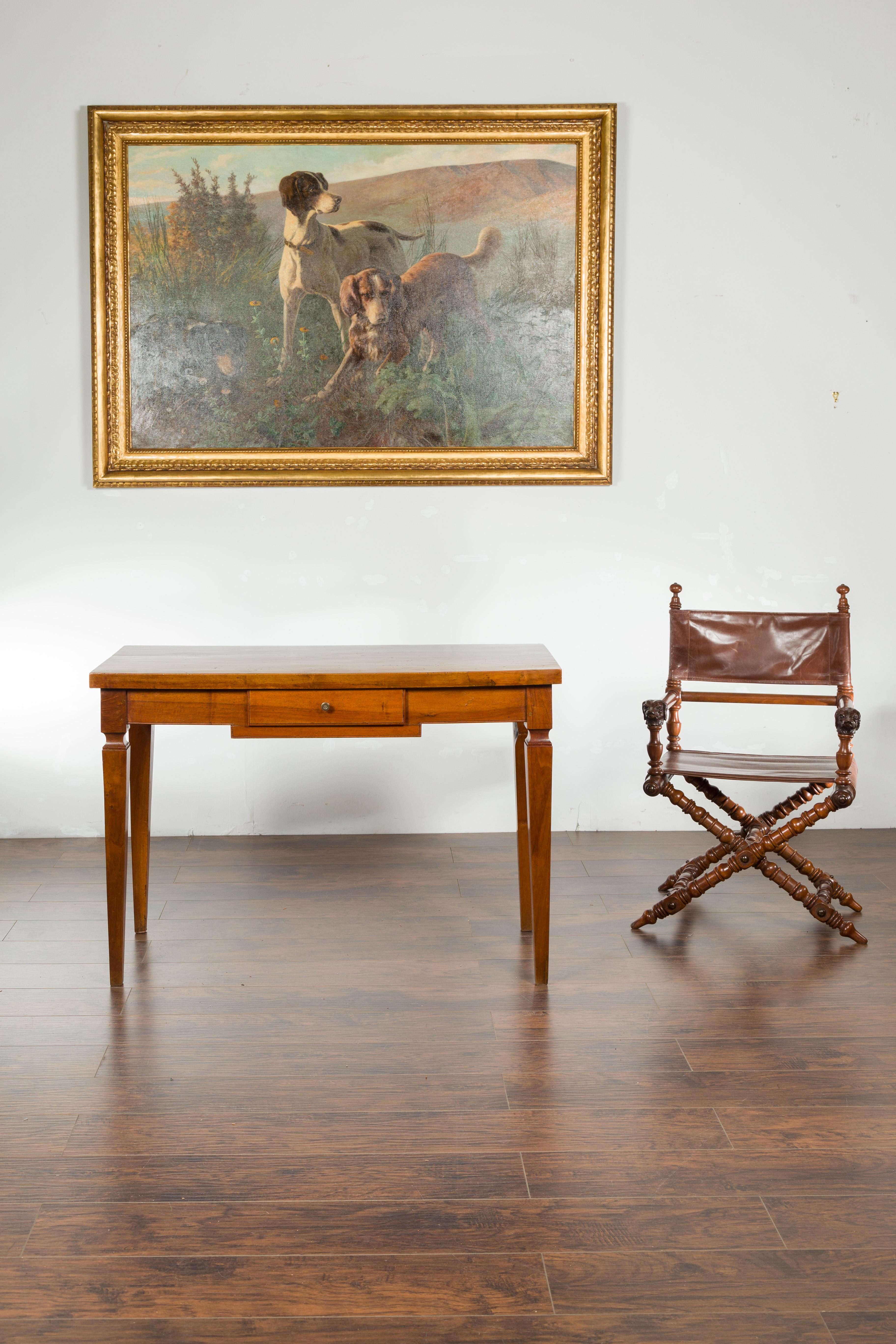 An Italian walnut desk from the 19th century, with single drawer and tapered legs. Created in Italy during the 19th century, this walnut desk features a rectangular single planked top sitting above a small drawer opening thanks to a brass pull.
