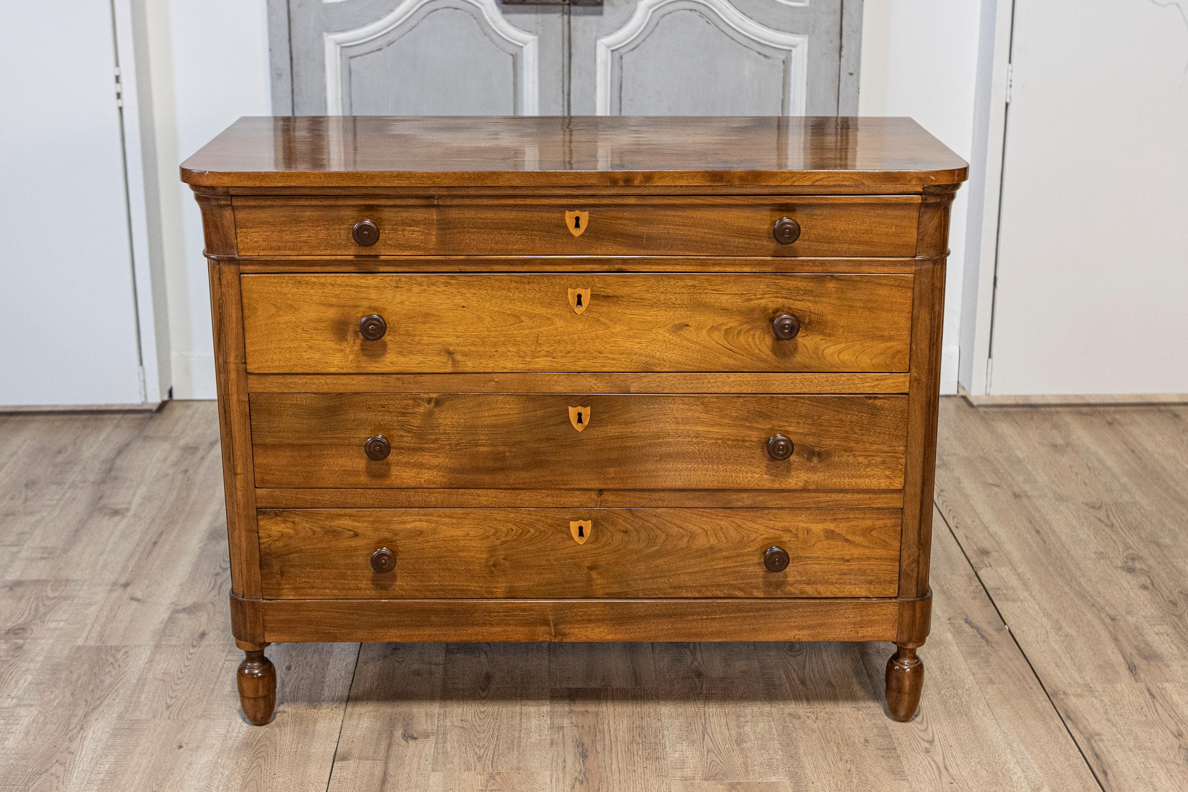 Una commode italiana in noce del XIX secolo con quattro cassetti e scudi intarsiati in frassino. Creato in Italia nel XIX secolo, questo mobile in noce presenta un piano rettangolare con angoli graziosamente arrotondati nella parte anteriore, per