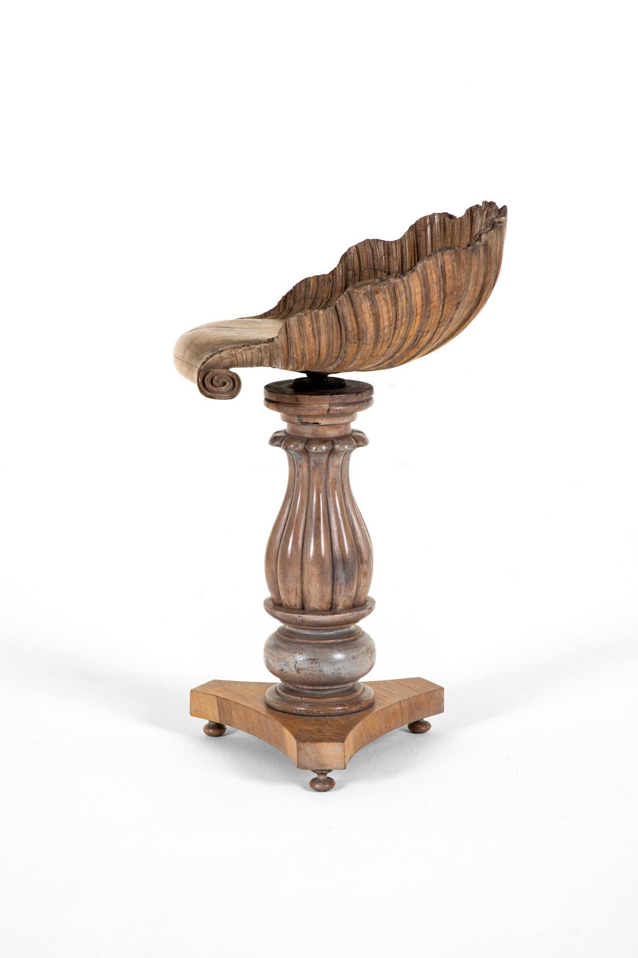 An exceptional and rare 19th century adjustable Grotto stool in walnut.

The chair features a large, scalloped shell-shaped backrest, hand-carved and finished with gentle scrolls to each side of the seat.

The seat has a rotating mechanism attached