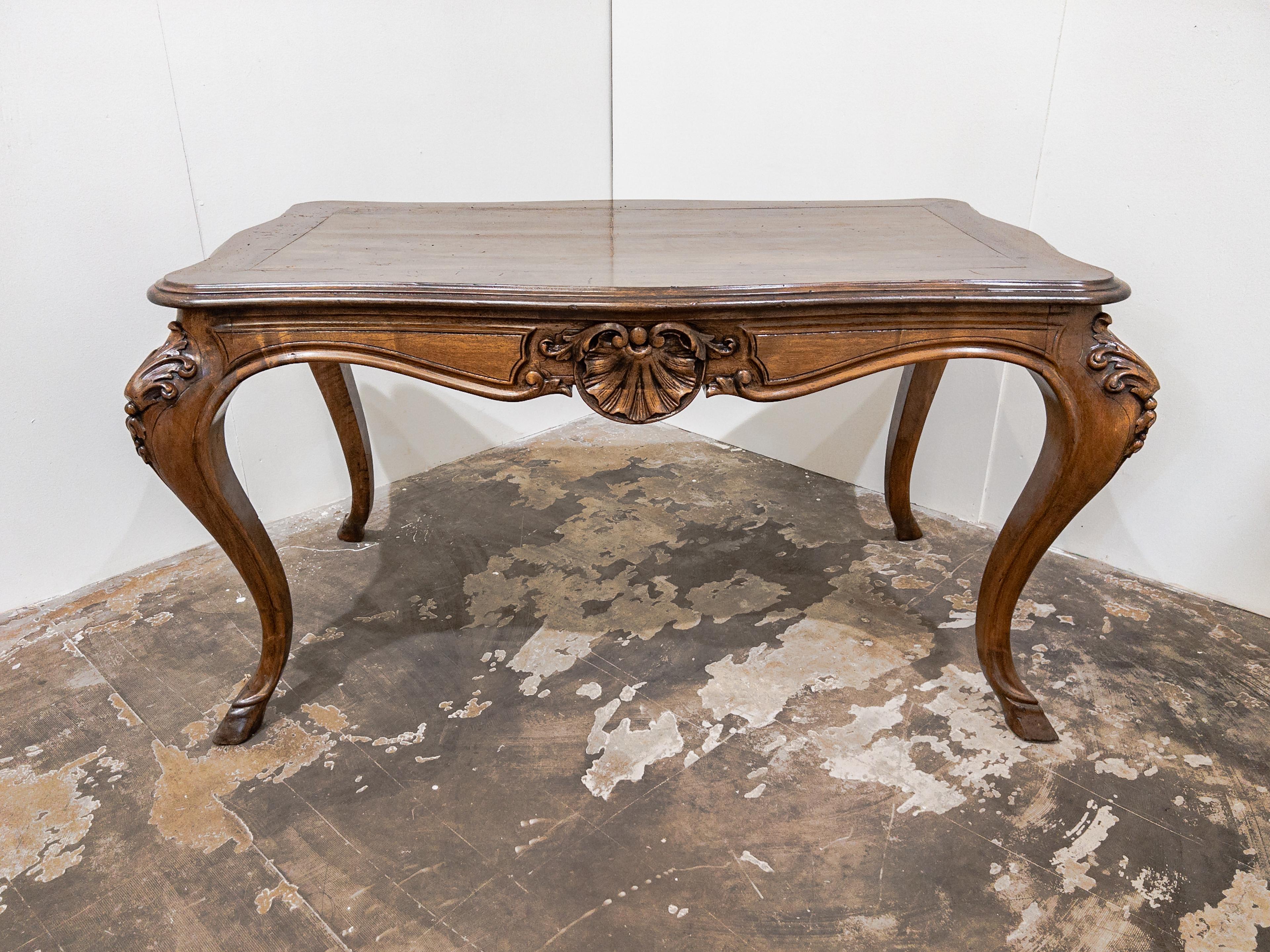 Italian 19th Century Walnut Louis XV Style Hoof Leg Table with a scalloped apron and carved details on the legs is an exquisite and finely crafted piece of furniture originating from Italy during the 1800s.

The table features a rectangular or