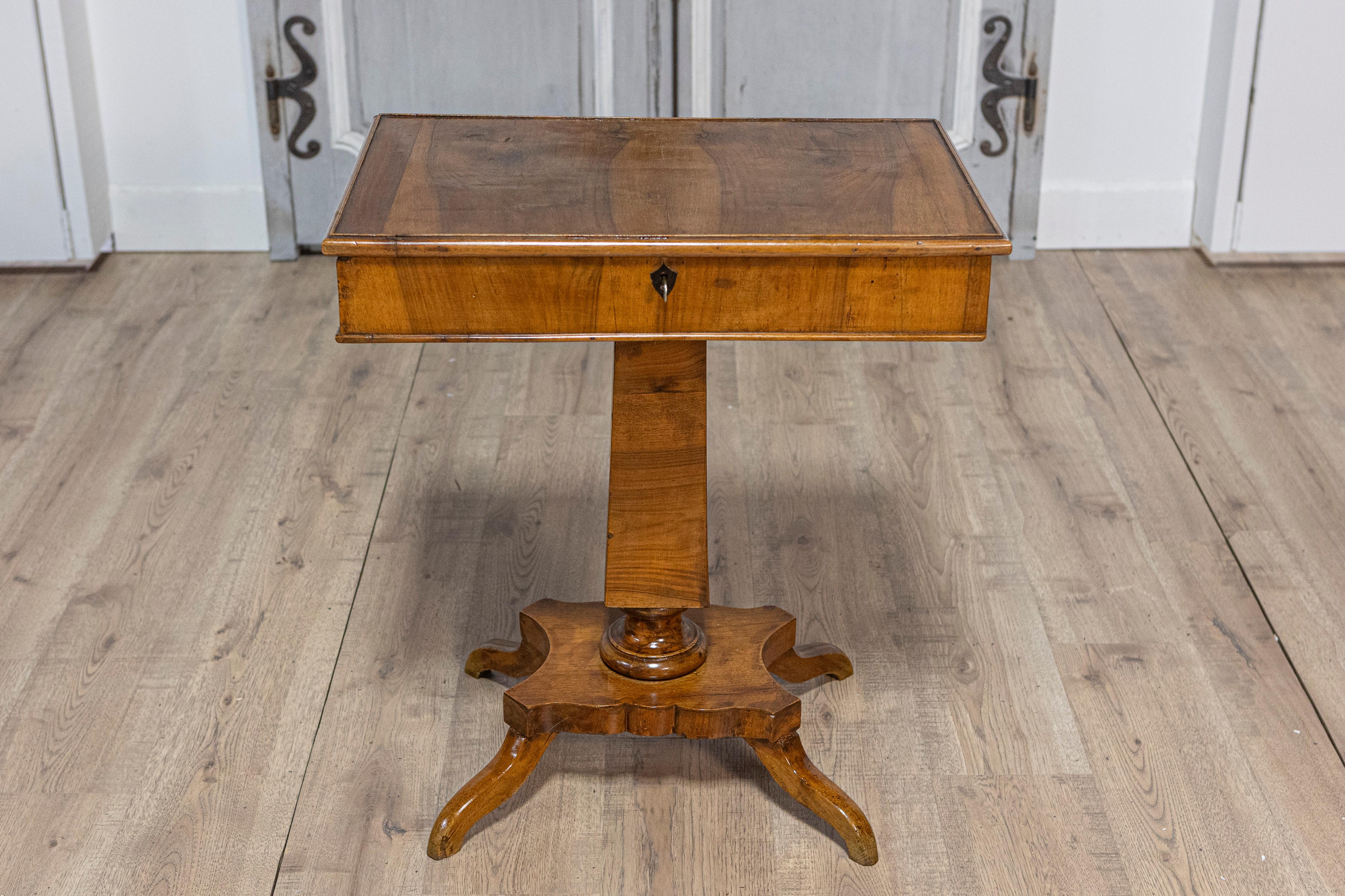 An Italian walnut pedestal table from the 19th century with single drawer and quadripod base. This exquisite Italian walnut pedestal table from the 19th century exudes classic elegance with its functional design and refined aesthetics. Featuring a