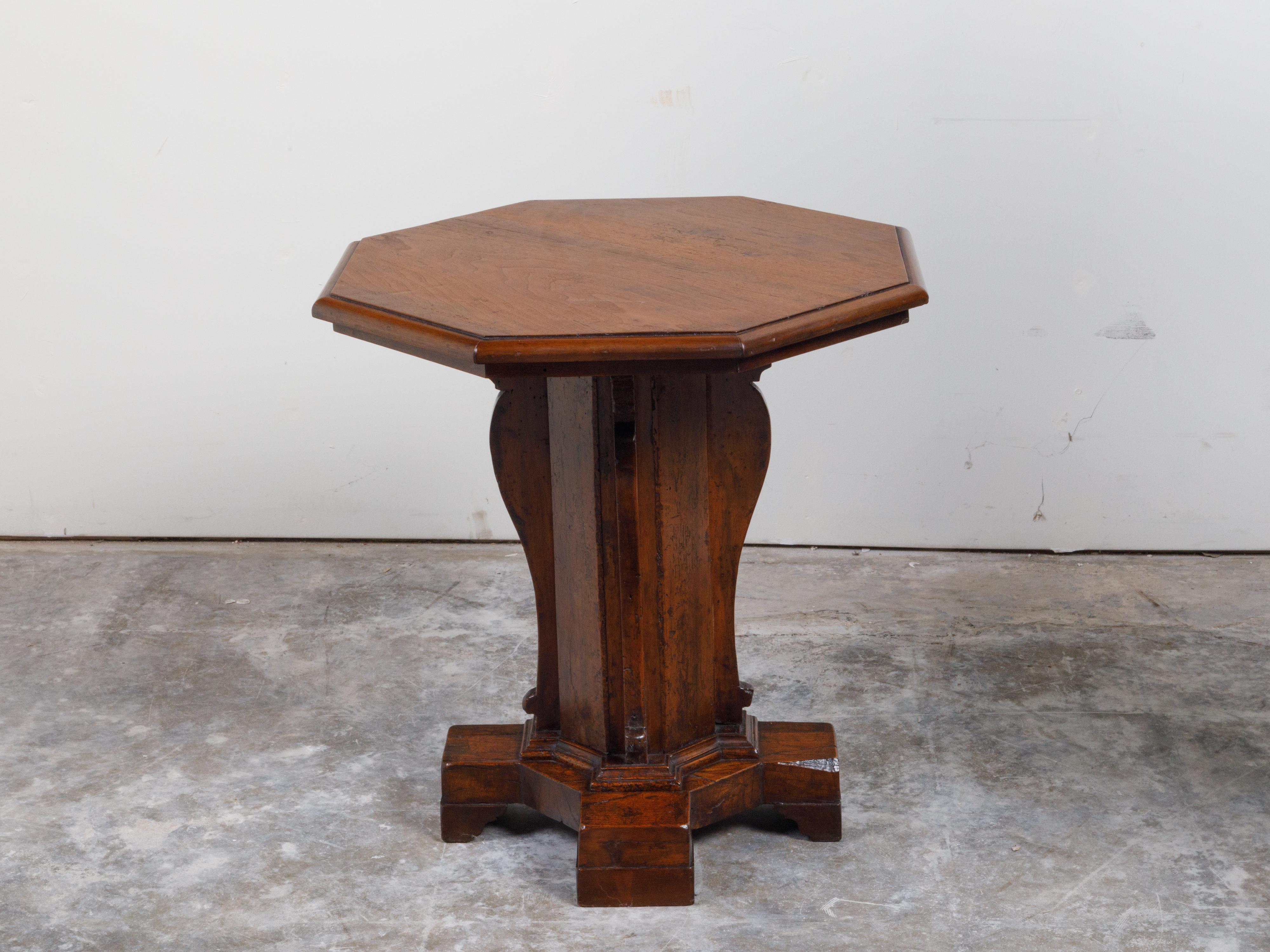 An Italian walnut side table from the 19th century, with octagonal top and pedestal base. Created in Italy during the 19th century, this walnut side table features an octagonal top sitting above a carved pedestal base accented with scrolling