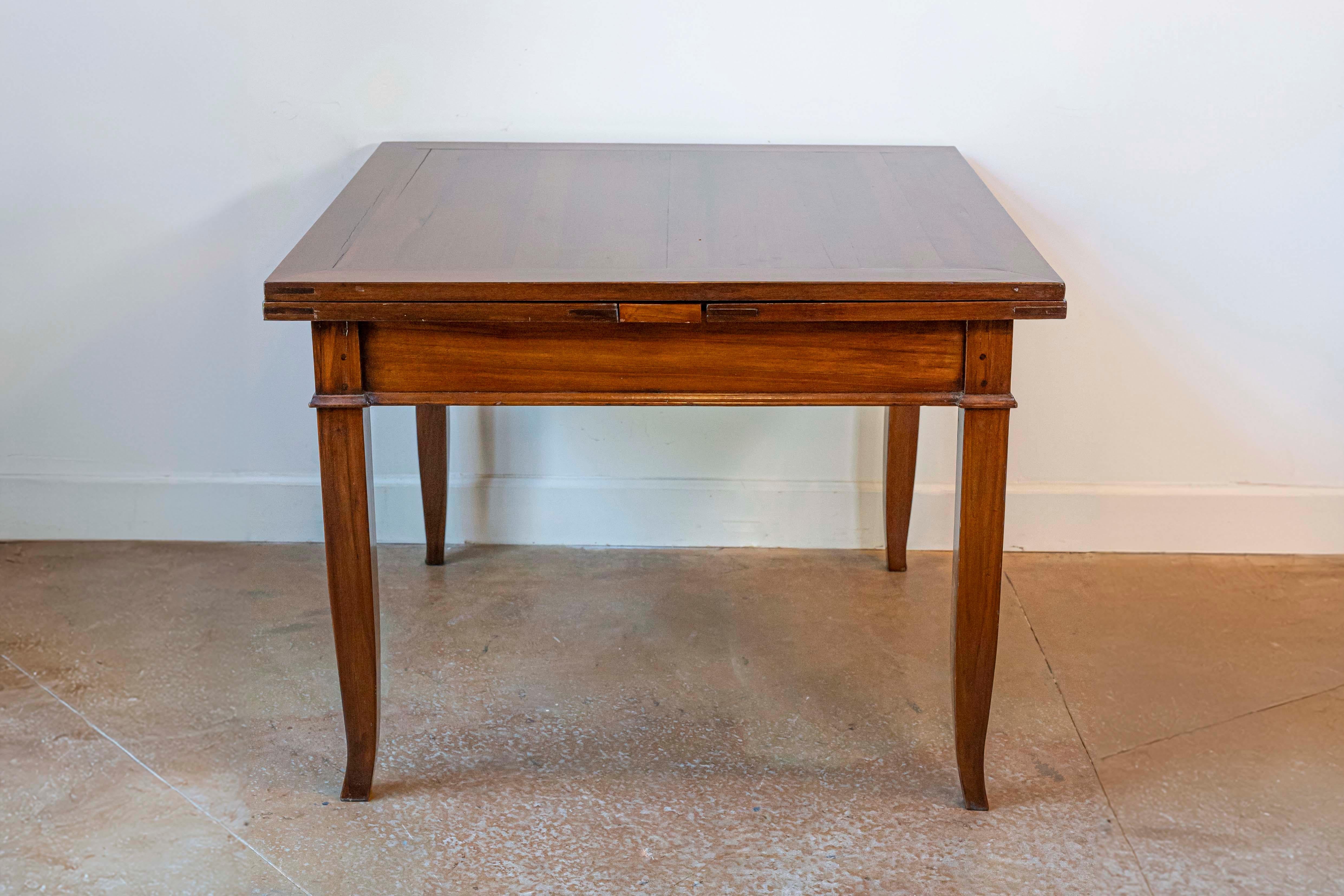 Table italienne en noyer du XIXe siècle, avec deux allonges, des pieds délicatement incurvés et une patine brun foncé. Créée en Italie au cours du XIXe siècle, cette table en noyer est dotée d'un plateau carré mesurant 41,2 pouces lorsqu'elle est