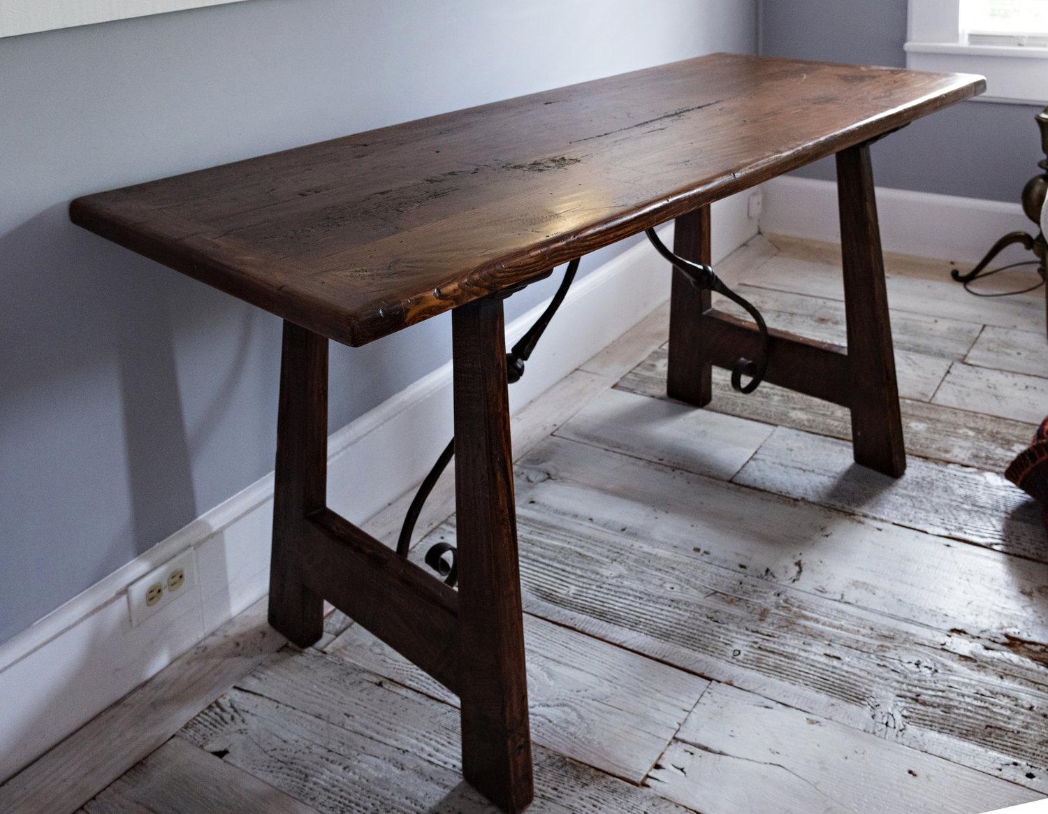 19th century Italian walnut trestle table with antique hand cast, wrought iron stretcher.