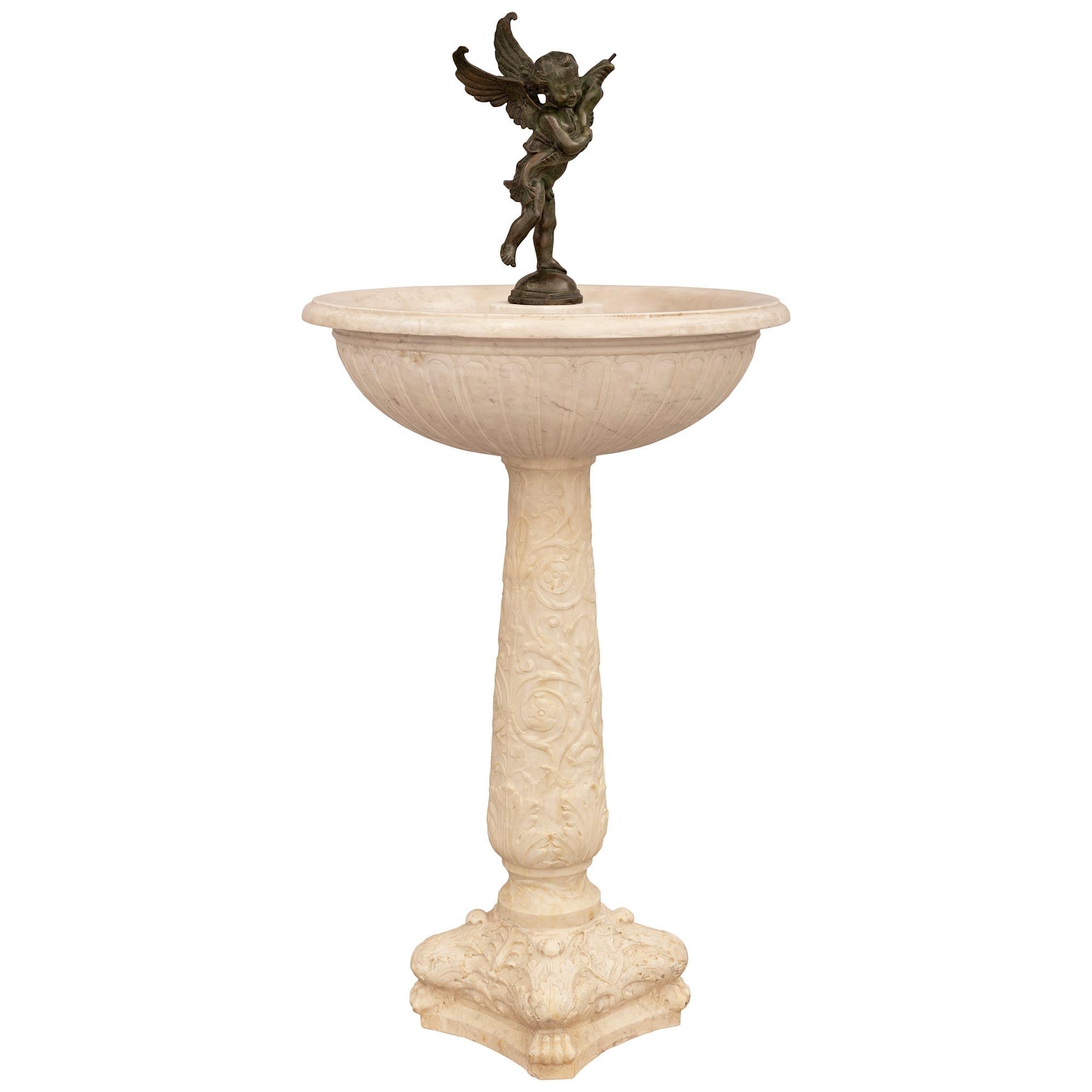 Une impressionnante et grande fontaine italienne du XIXe siècle en marbre blanc de Carrare et en bronze patiné. Cette étonnante fontaine est surélevée par une base carrée avec des pattes sculptées à chaque coin et des feuilles d'acanthe au-dessus.