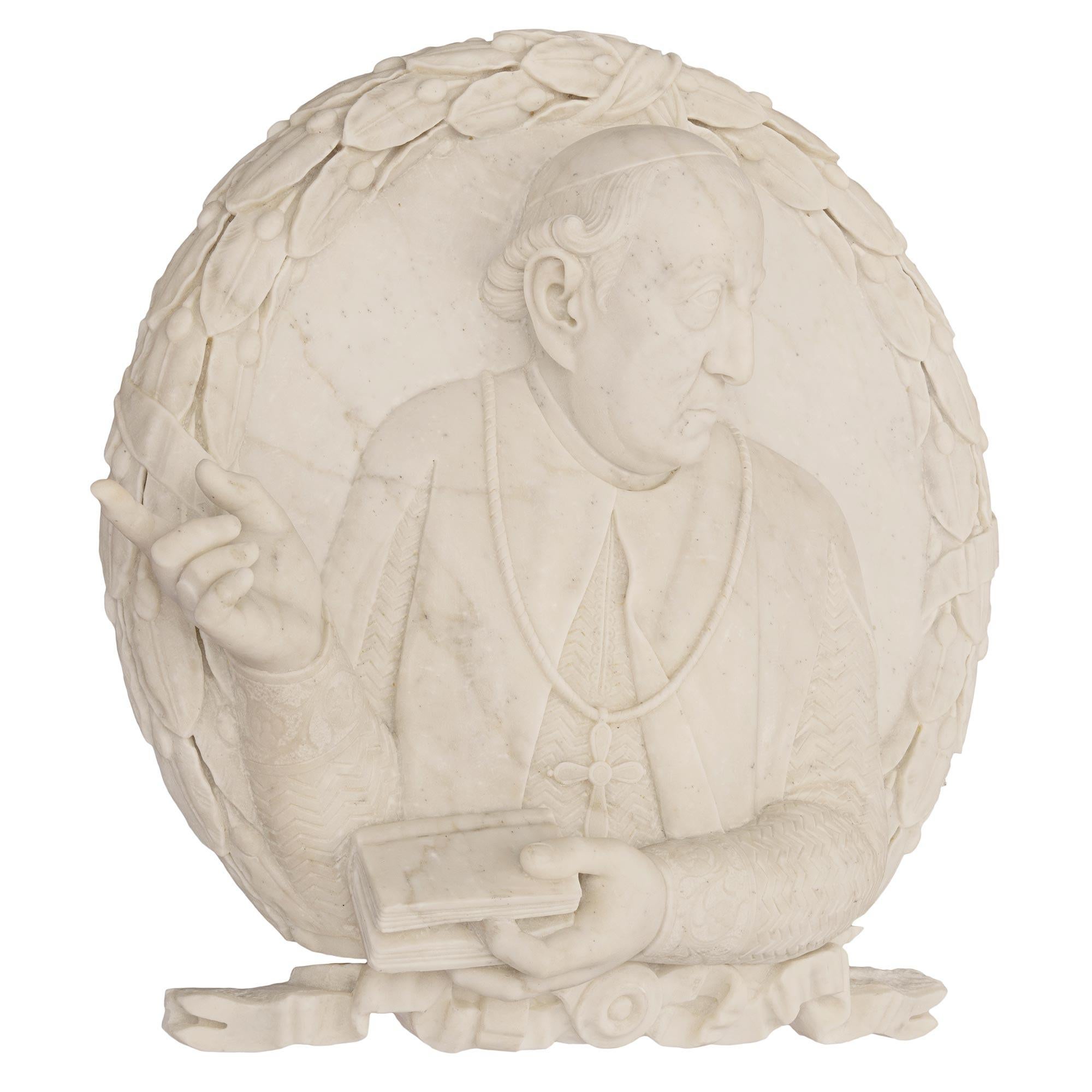 A striking and finely detailed Italian 19th century white Carrara marble decorative wall plaque of a pope. The plaque, sculpted out of one solid piece of white Carrara marble, depicts a Pope at the center dressed in his traditional cassock with a