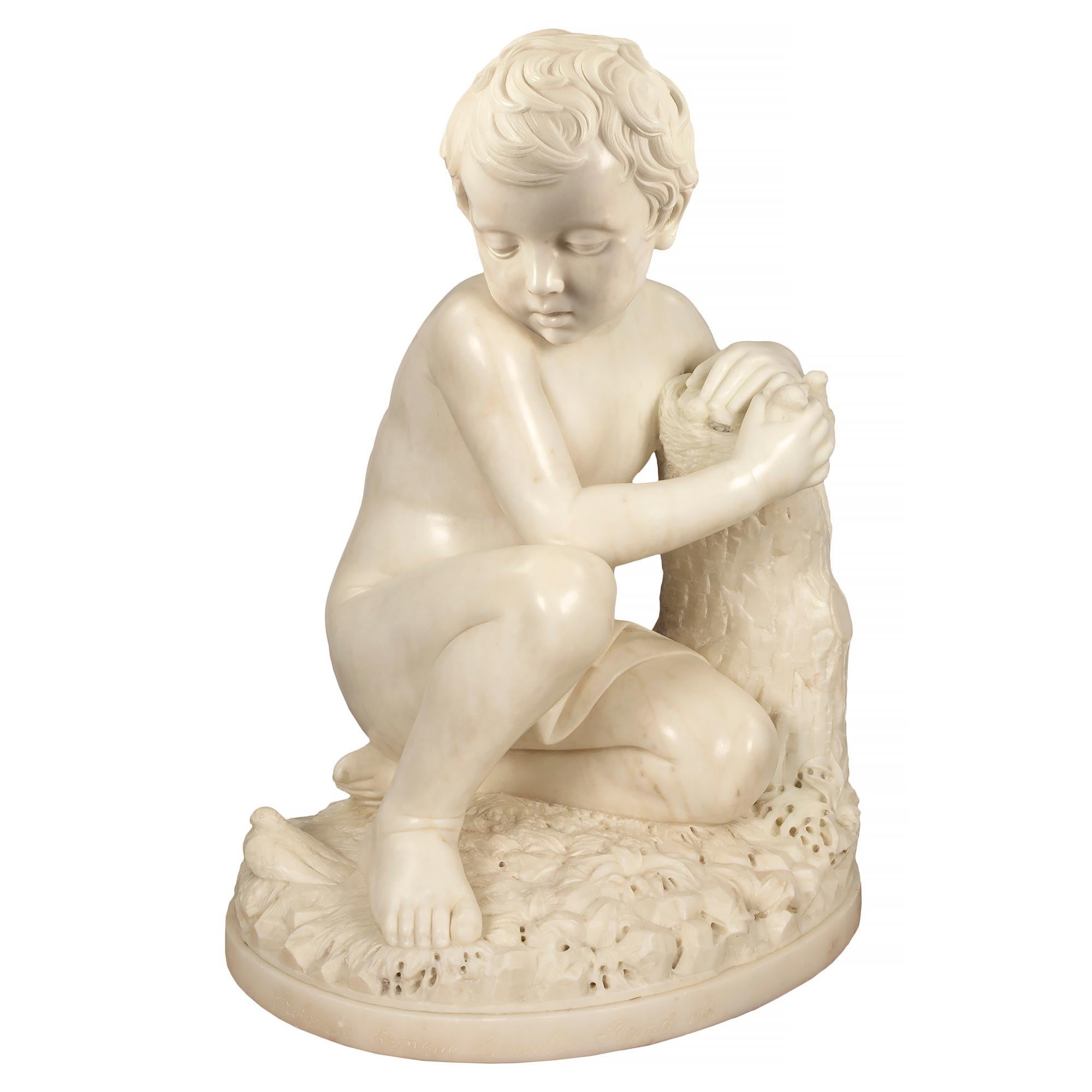 A striking Italian 19th century white Carrara marble statue of a young boy sitting next to a tree trunk signed Professore Eumene Baratta Roma 1861. The statue is raised by a circular base with a fine mottled border and a wonderfully executed rock