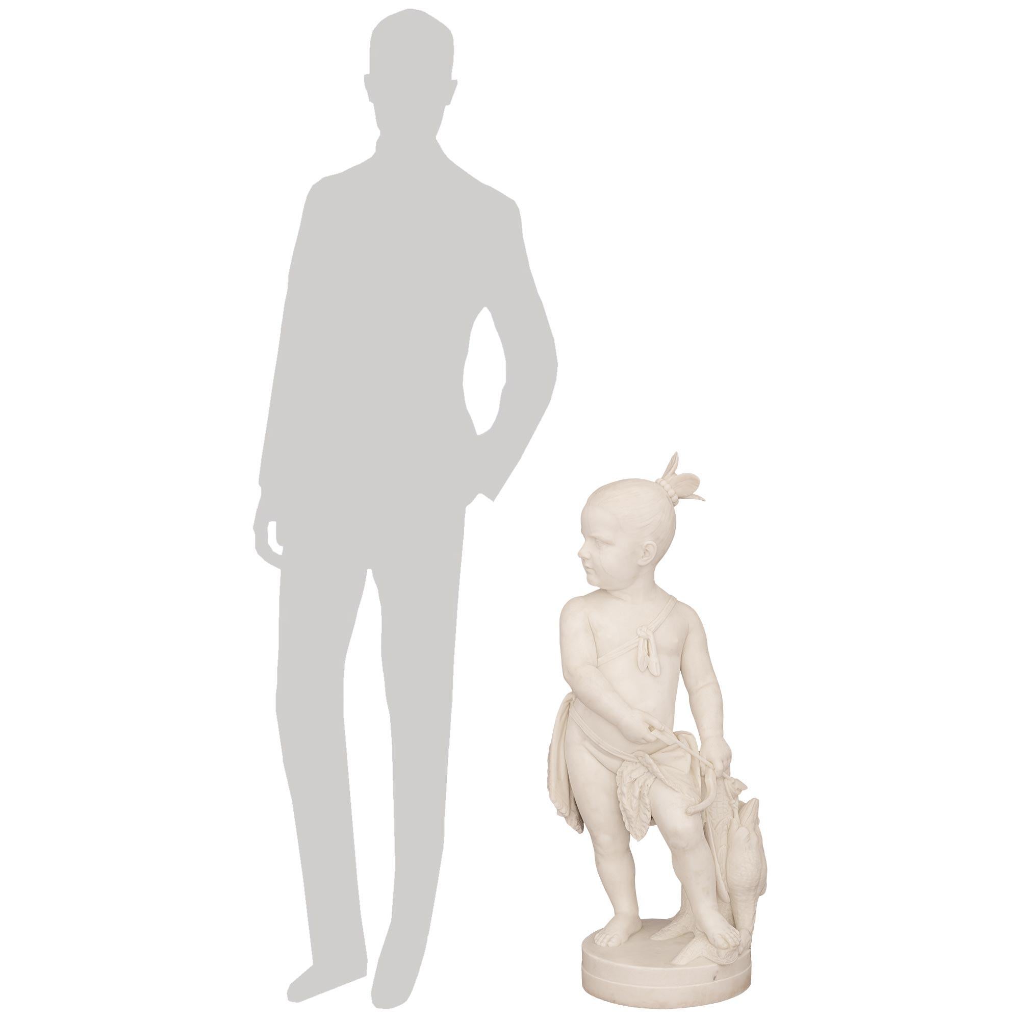 Eine charmante und hochwertige italienische Statue aus weißem Carrara-Marmor aus dem 19. Jahrhundert mit dem Titel Indian Boy Hunting, signiert Randolph Rogers, Rom, um 1866. Der Junge steht stolz neben einem Baumstumpf über einem runden Sockel mit