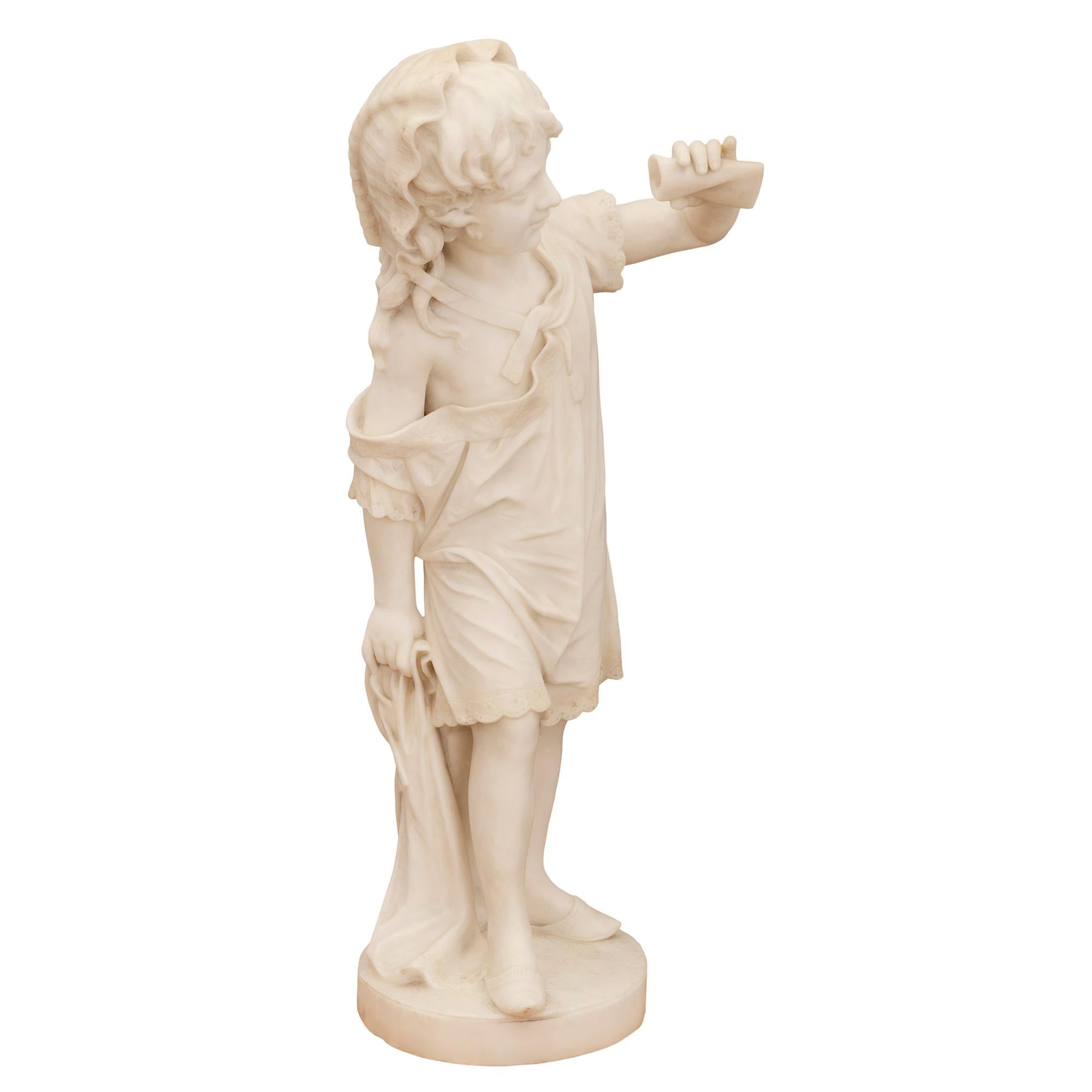 Un'affascinante statua in marmo bianco di Carrara del XIX secolo di alta qualità raffigurante una giovane ragazza che regge una pergamena. La statua è sollevata da una base circolare con un motivo a forma di diamante finemente scolpito. L'adorabile