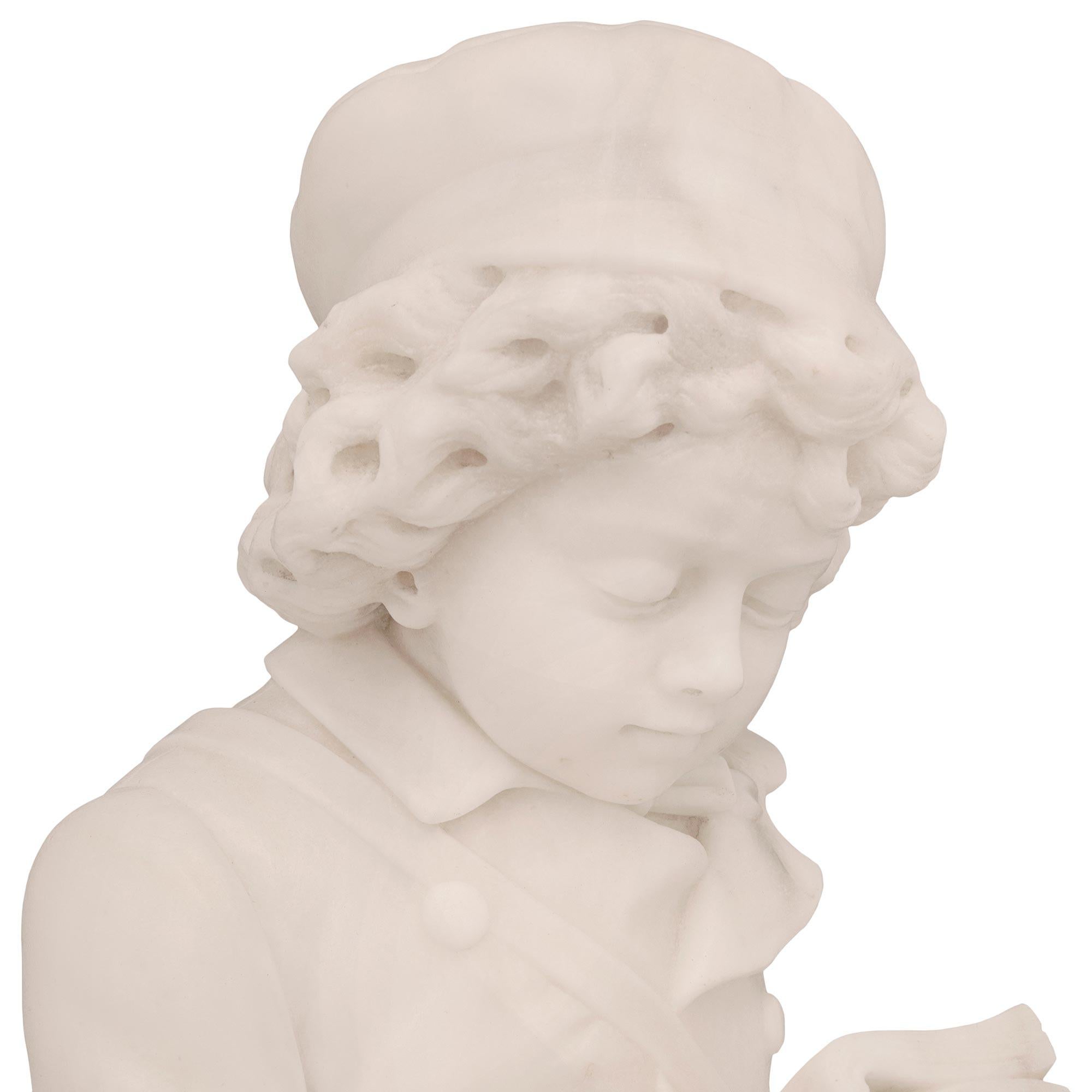 A beautiful and very high quality Italian 19th century white carrara marble statue of a young boy reading a book. The statue is raised by a circular mottled base with lovely ground like designs and fine sculpted blooming flowers. The young boy is