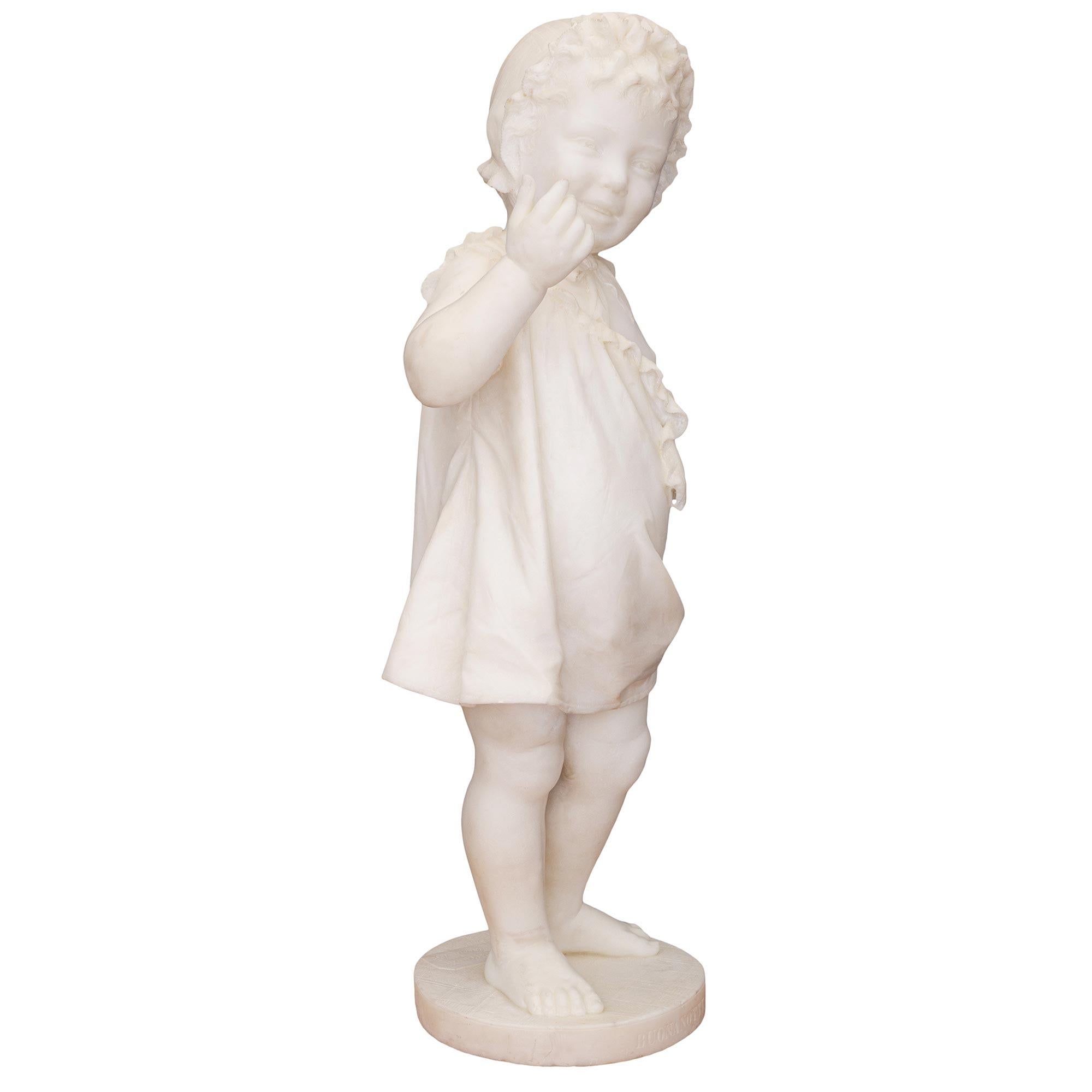 A most charming and wonderfully executed Italian 19th century white Carrara marble statue of a young girl, titled BUONANOTTE. The statue is raised by a circular base with a fine paver like design and the inscription BUONANOTTE at the front meaning
