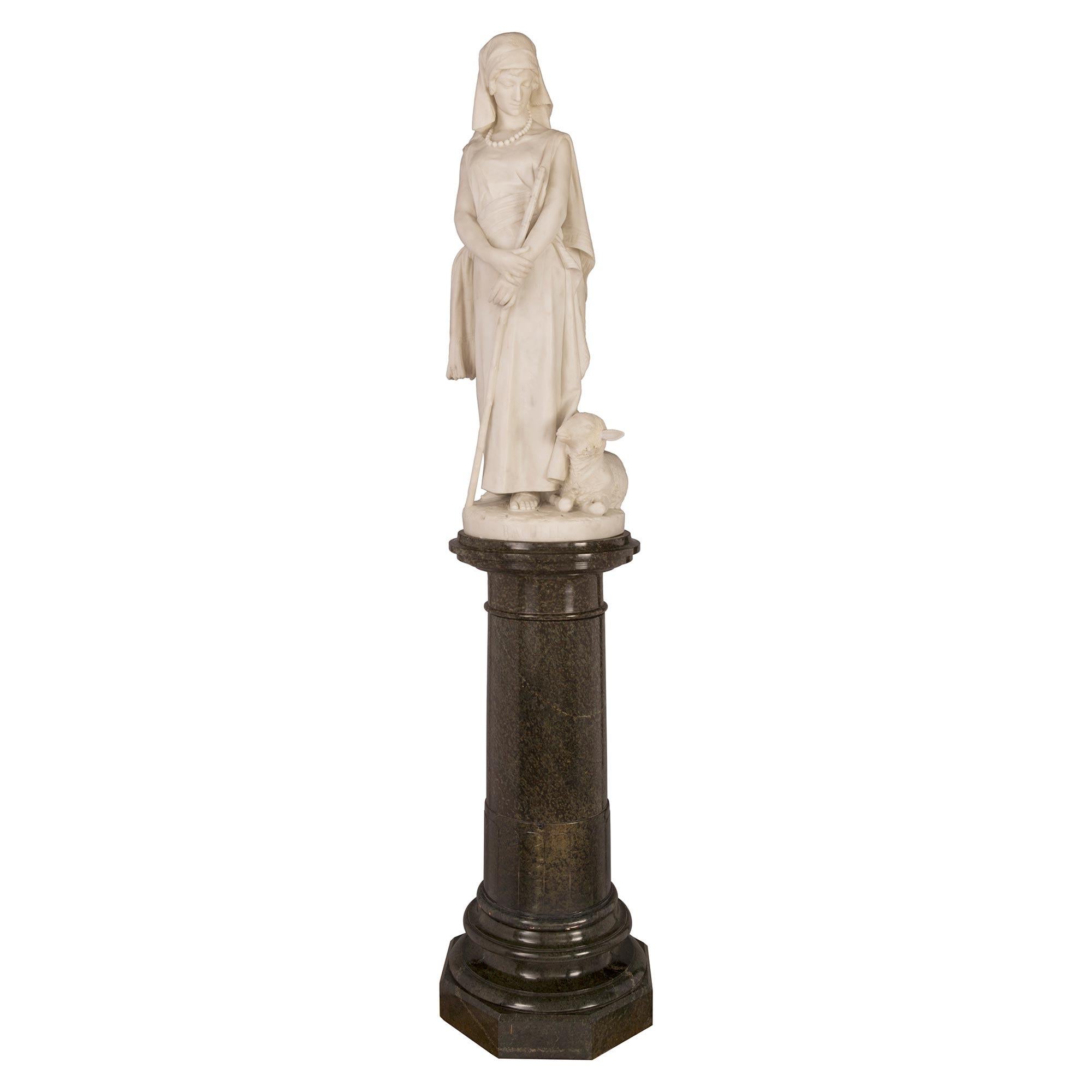 A stunning and large scale Italian 19th century white Carrara marble statue of Rachele and Lamb on it's original Vert de Patricia marble pedestal, signed F.Vichi. Firenze. The statue is raised by a its original pedestal with an octagonal base and