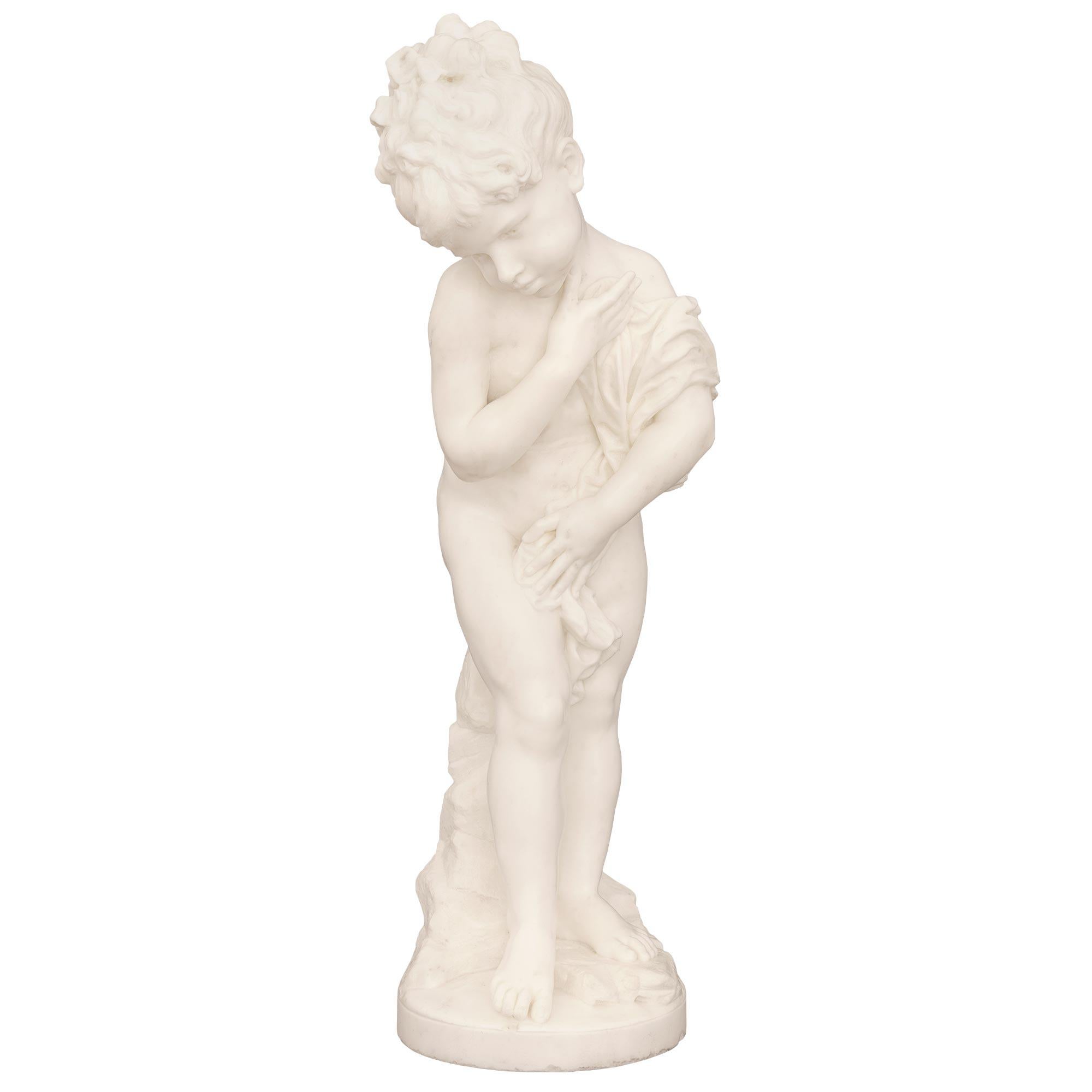 A beautiful and very high quality Italian 19th century white Carrara marble statue signed F. Mariotti Scul. The statue is raised by a circular base with exceptional ground and rock designs leading up the back. The statue depicts a beautiful young