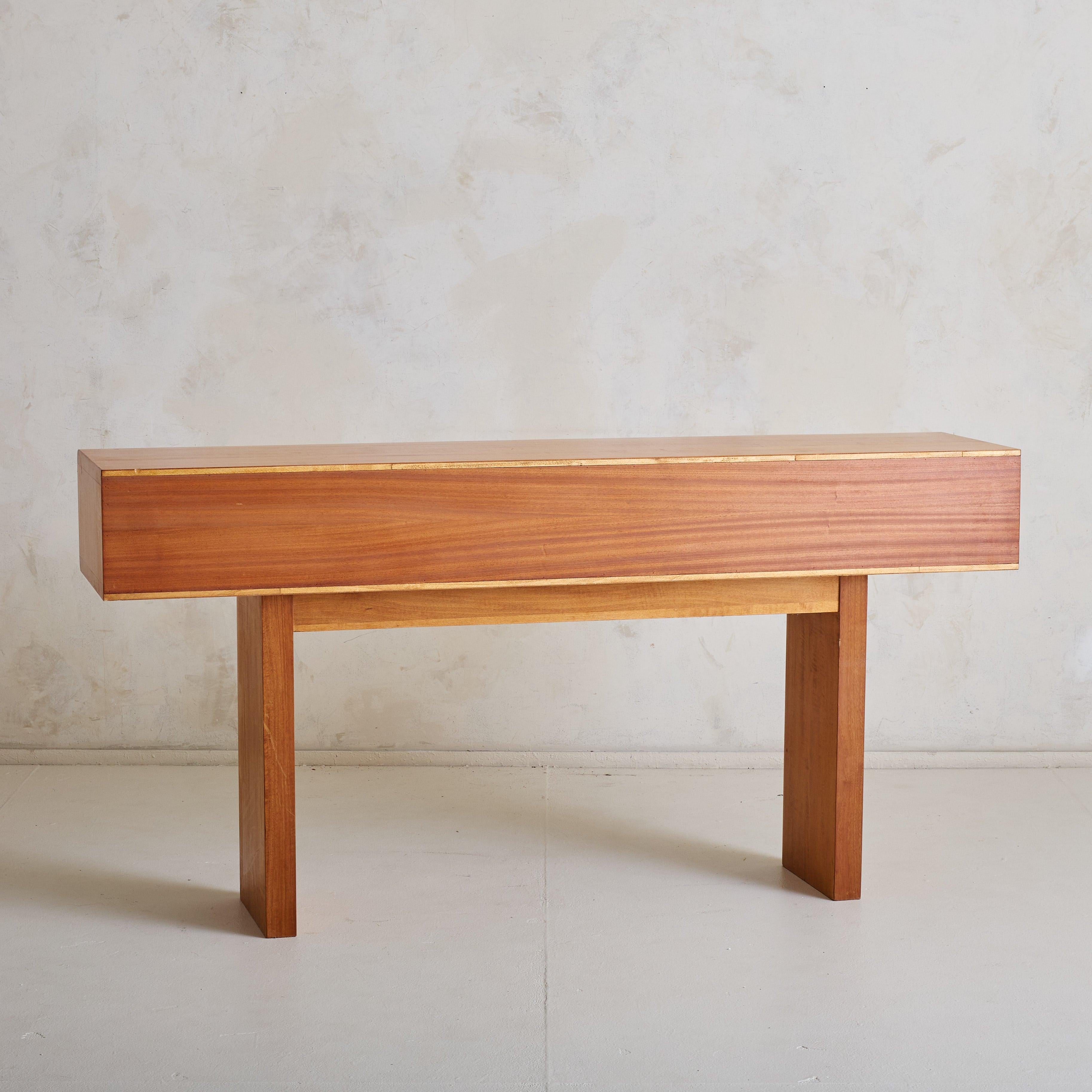 A 1960s Italian Mid-Century Modern console, showcasing exquisite craftsmanship and architectural simplicity. Constructed from warm-toned solid wood, the piece features impeccable joinery, with seamlessly integrated drawer pulls. The two drawers