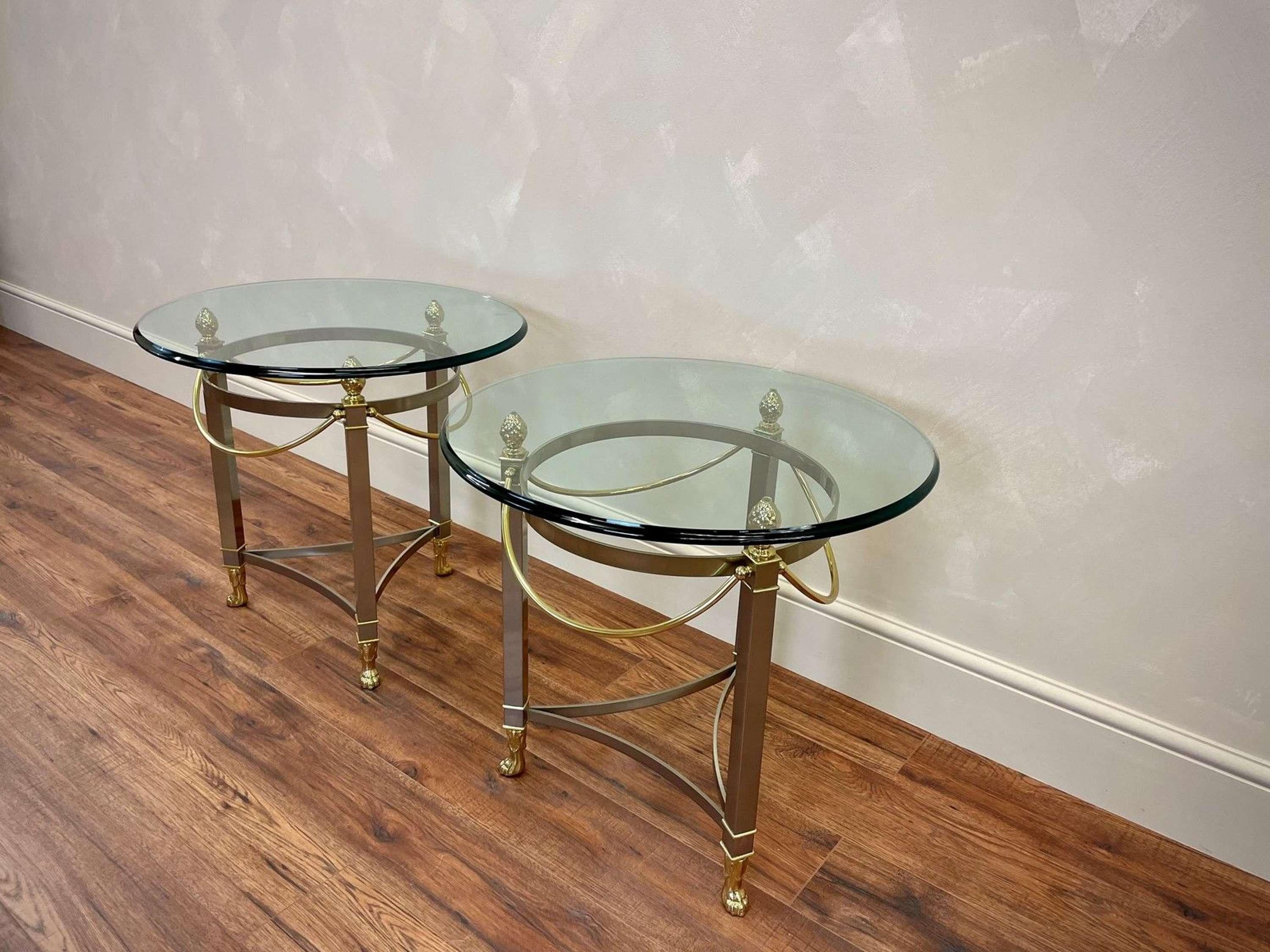 Italian, 20c Hollywood Regency style, midcentury side tables in glass, brass and brushed chrome.
Thick, glass tops with bevelled edge resting on gold pineapple supports.
Age related wear 
Lion paw feet finish the angular and swag