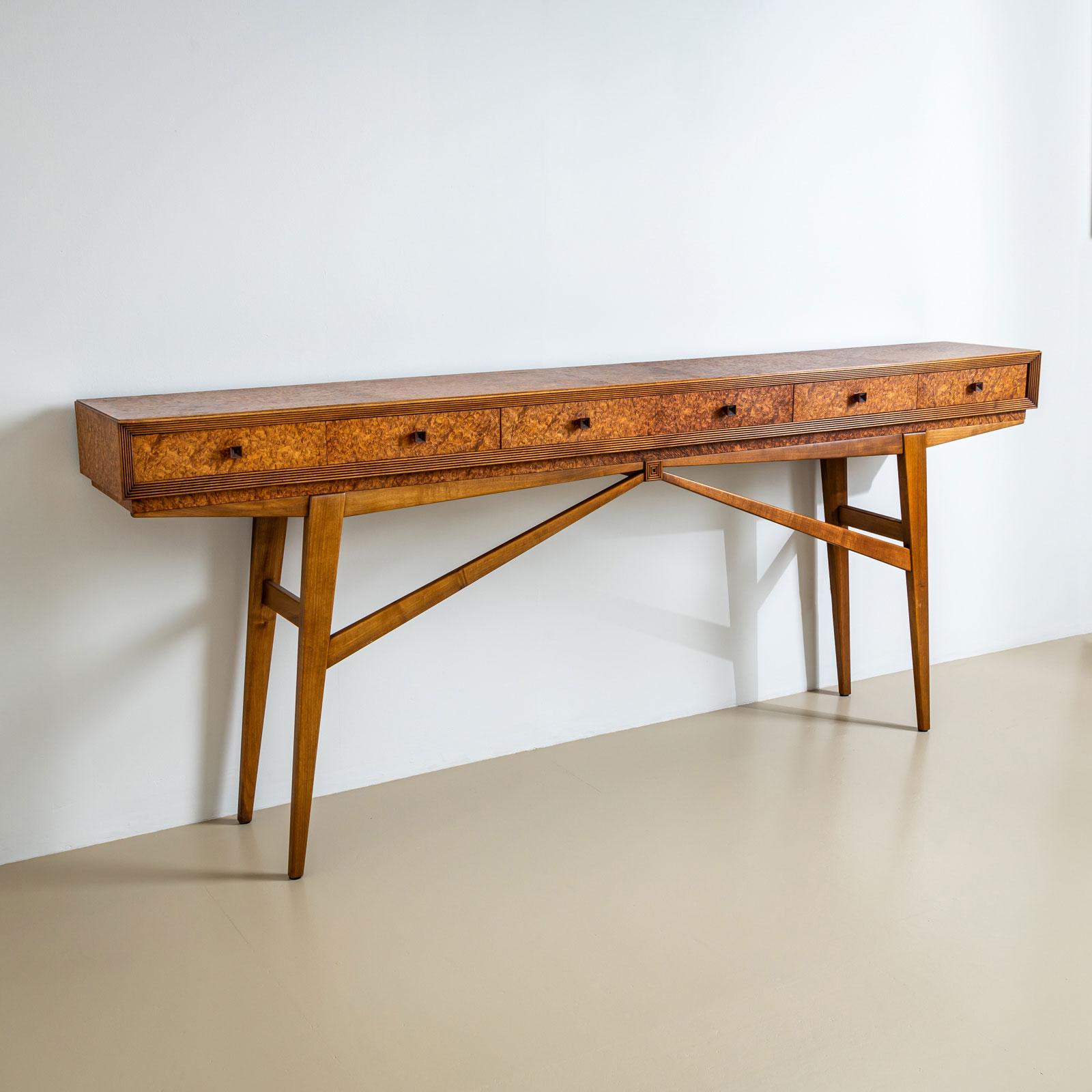 Long console table with six drawers and a burl veneered surface with profiled edges. The console table stands on an elegant frame with tapering legs and elegant struts. The console table has been professionally restored and polished. The fine veneer