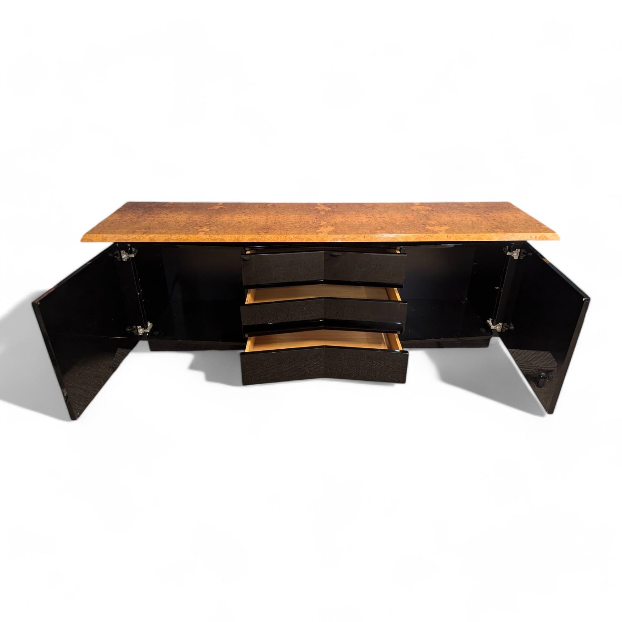 This Italian mid-20th century sideboard by Jean Claude Mahey is a stunning example of mid-century modern design, featuring the rich, textured beauty of elm burl wood. The warm, organic patterns of the elm burl create a natural yet luxurious feel,