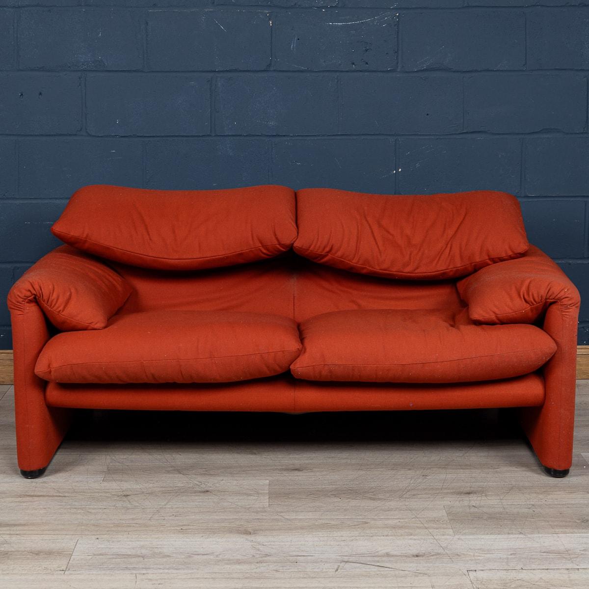 A 2-seater “675 Maralunga” sofa in red fabric. The Maralunga sofa was designed by Vico Magistretti in the early 1970s for Cassina. Cosy and adaptable, the ever cool sofa was an instant classic. Comfort comes in 2 forms with a backrests that