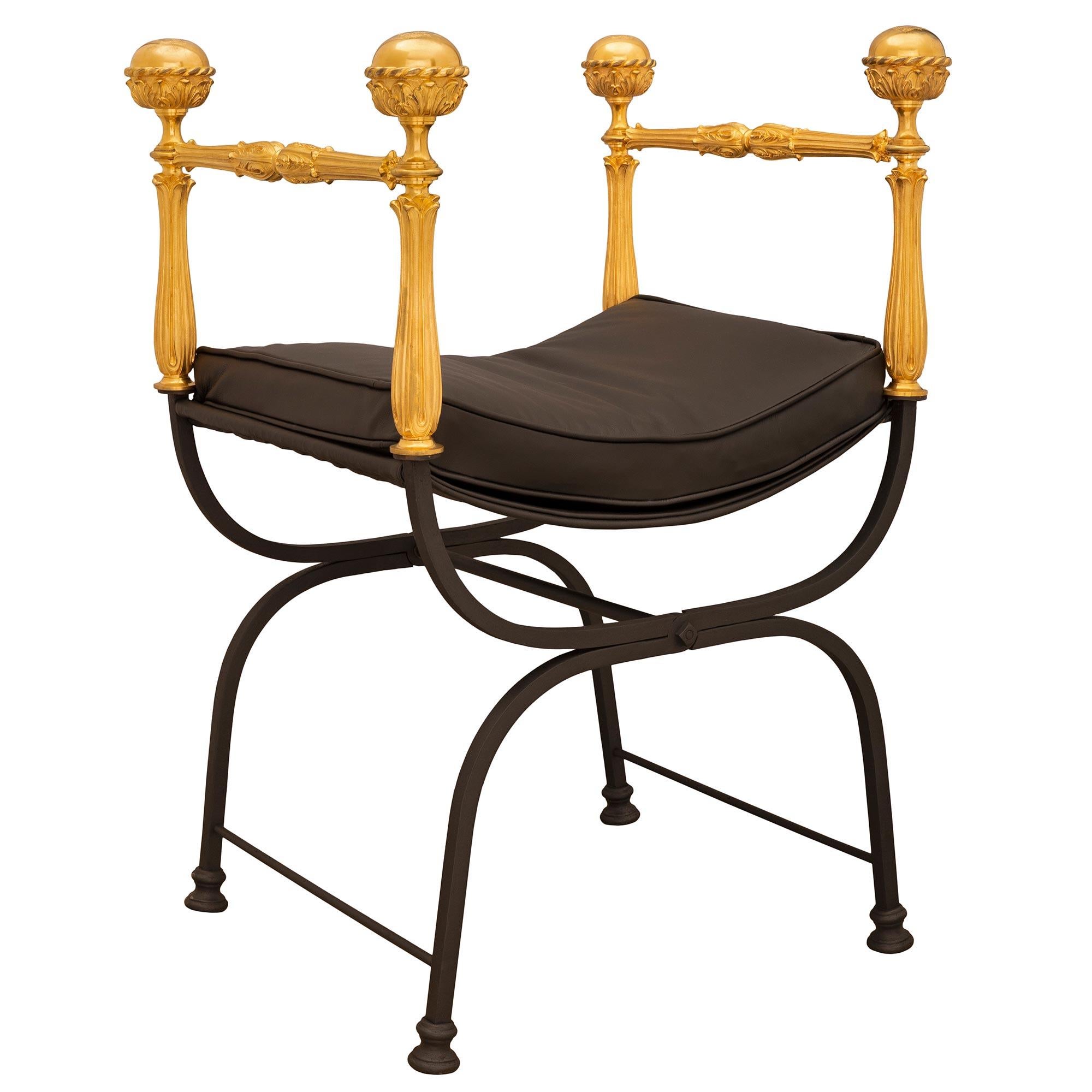 A striking and most decorative Italian 20th century Renaissance st. wrought iron and ormolu Savanarola bench. The folding bench is raised by a beautiful X-shaped wrought iron base with fine circular mottled feet connected by a stretcher. Above are