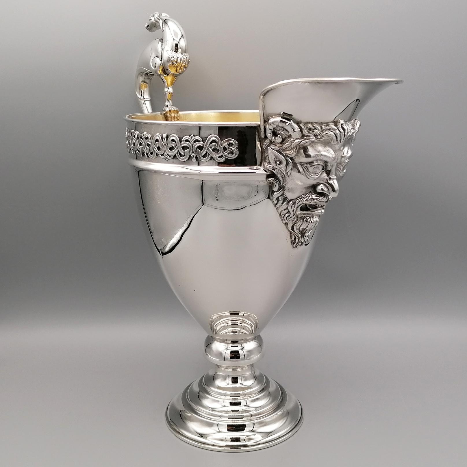 Renaissance-style solid silver jug, characterized by a central mask positioned under the spout and border with sixteenth-century motifs and handle with mythological animal.
Gold-plated interior.

Italian silverware, already with a centuries-old