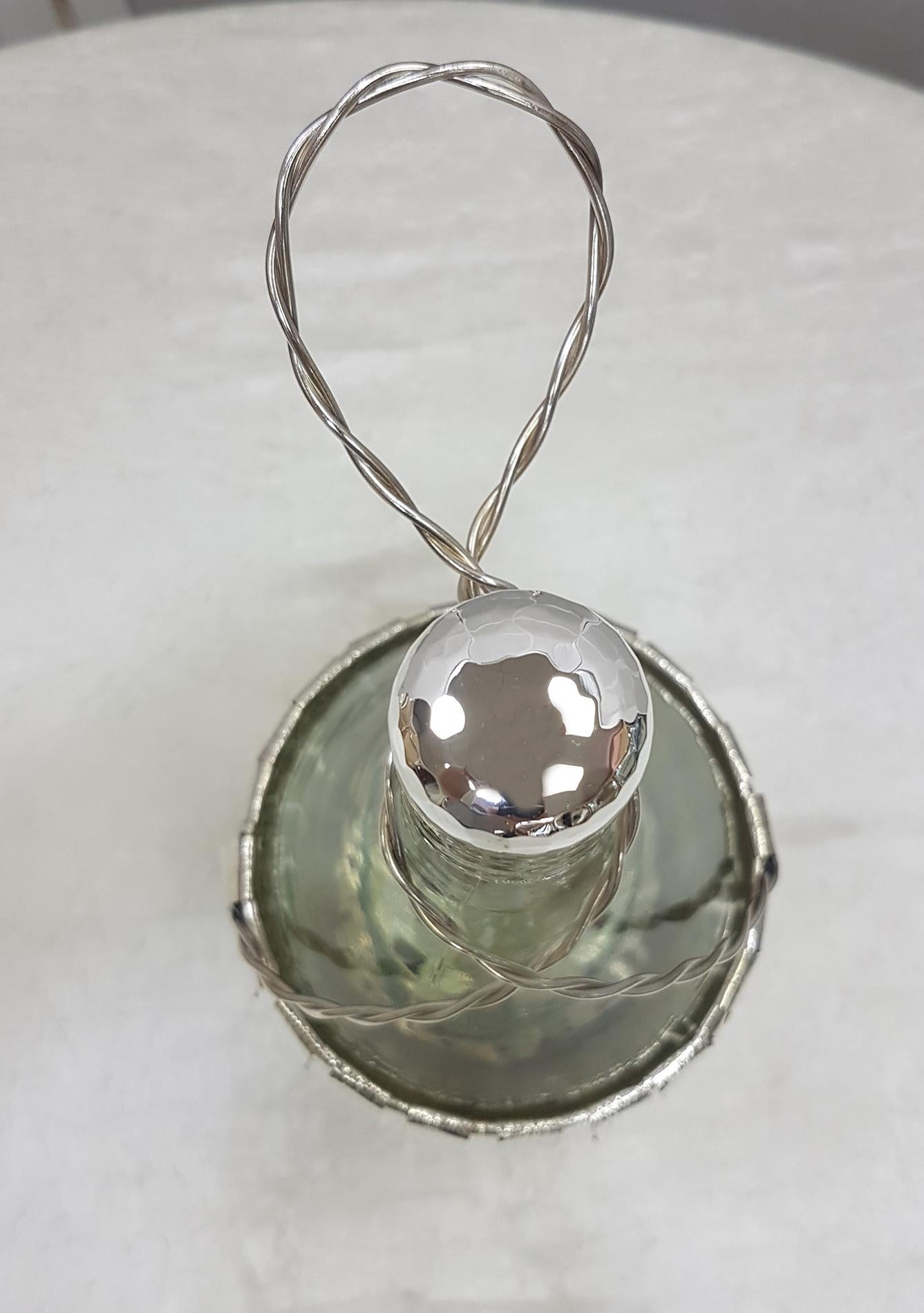2-liter white glass fiasc for red wine covered with 800 solid silver worked entirely by hand which takes up the classic straw processing. The cap is also in solid silver.
 