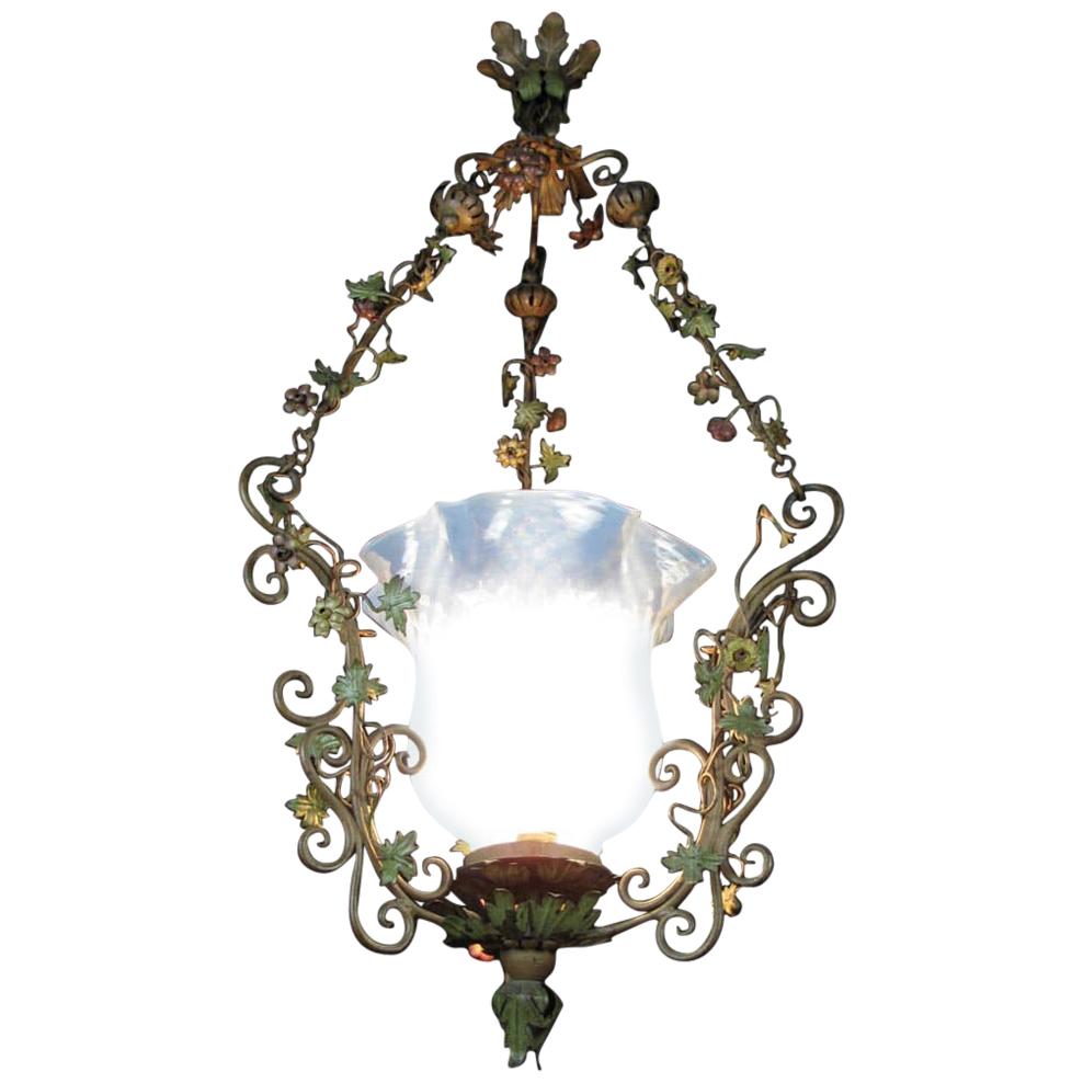 A floral Art Nouveau wrought iron lantern from Italy, with three vertical uprights decorated by shoots of polychrome red and amber flowers and leaves.
This hand-made iron chandelier has a great oxide green original painting, material is original of