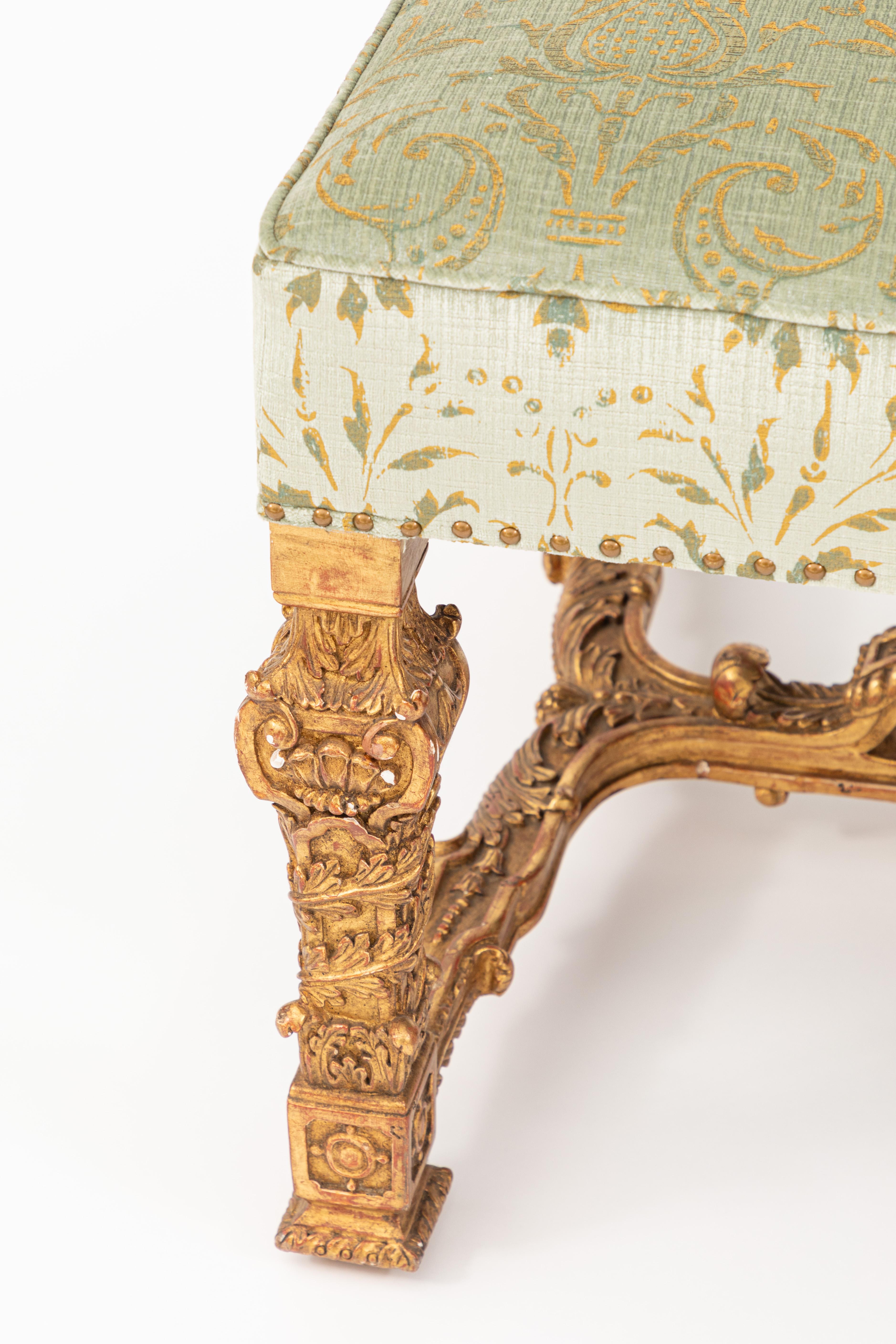 Italian 22-karat gold leaf carved wood bench newly upholstered with printed velvet fabric. Not antique.