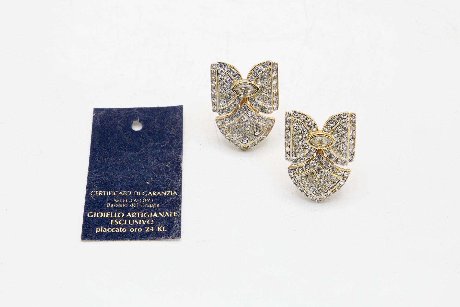 Elegant pair of Italian bow-shaped earrings with clips in the back. The earrings are 24 kt. gold plated and are finely implemented with rhinestones, including a central one.
The earrings were forged in Bassano del Grappa Brescia italy by an Italian