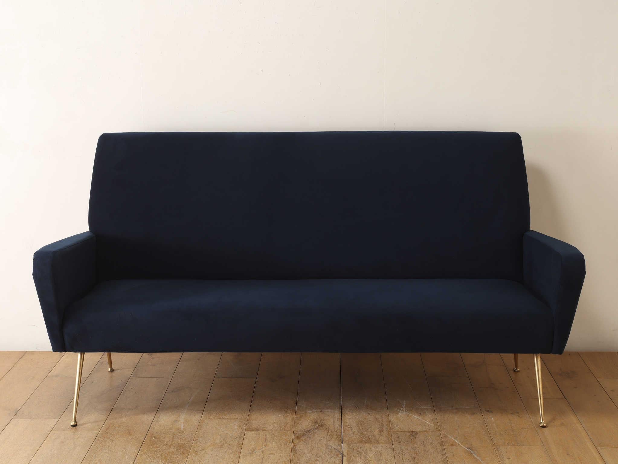 This sofa is believed to have been crafted in Italy around the 1950s. It showcases the elegance and refinement typical of mid-century Italian design, with its slim, elongated brass legs that lend a graceful and sophisticated silhouette. The overall