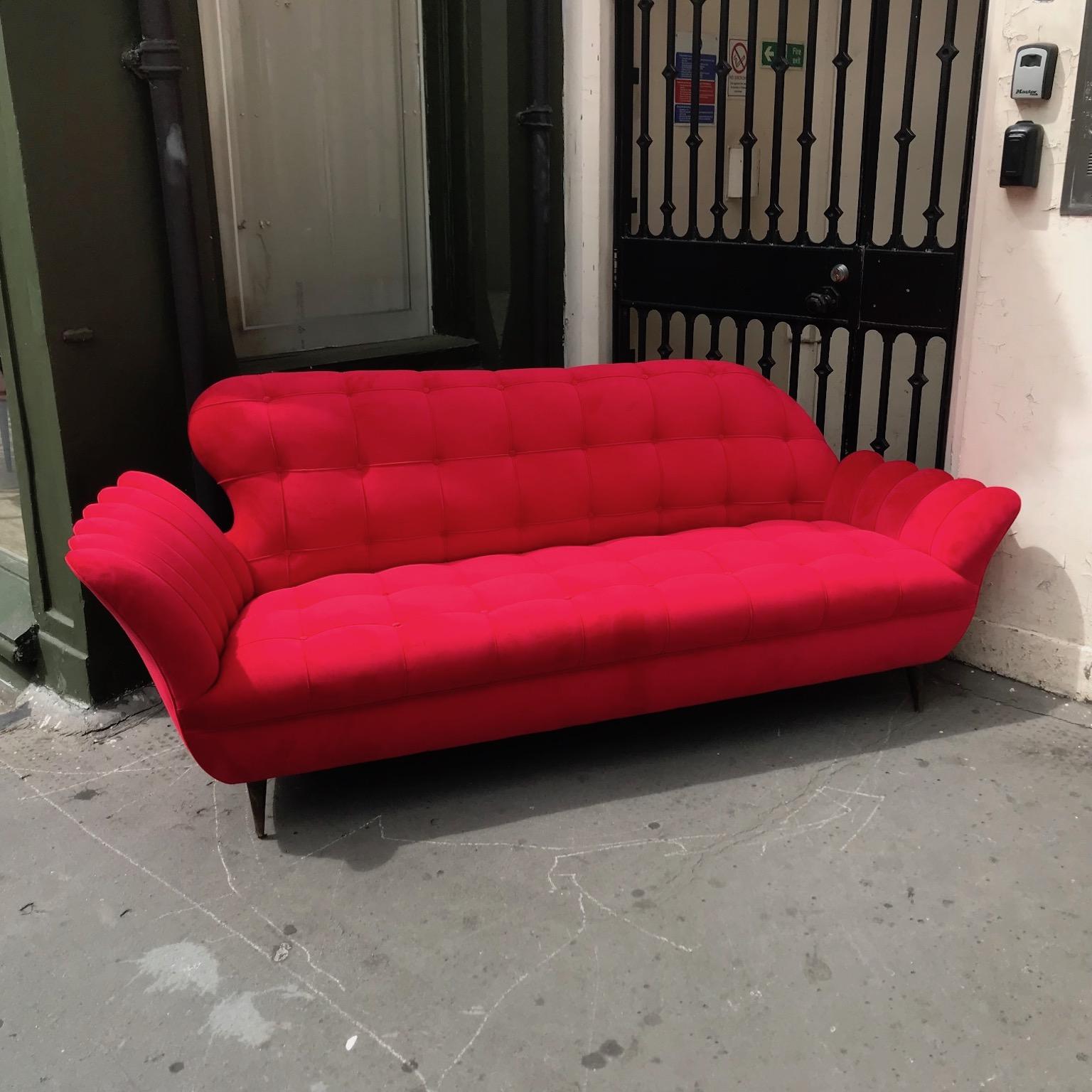 This elegant, sculptural, scalloped design sofa gives beauty and charm in any room in your house, been reupholstered in red velvet and feet been replaced to original brass feet. Italy c.50's attributed to Carlo Enrico Rava
