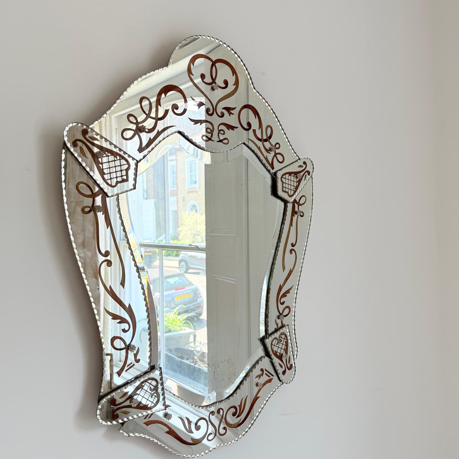 Miroir vénitien italien des années 50 avec des panneaux de miroir sectionnels gravés et des décorations autour.
