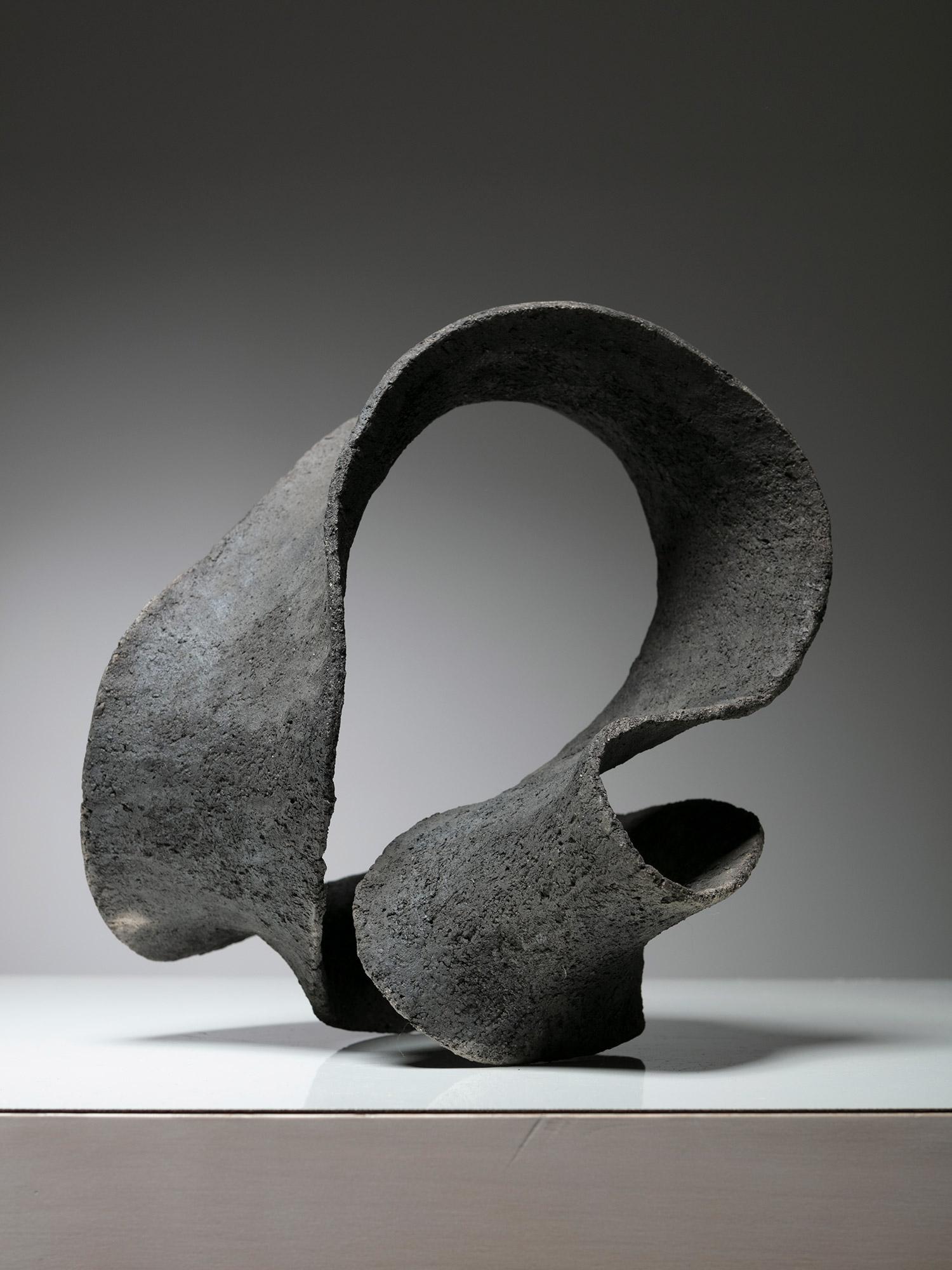 Keramische Skulptur, bestehend aus einem sich drehenden Kontinuumsstreifen. 
Das Werk erinnert an die Kunstwerke von Max Bill