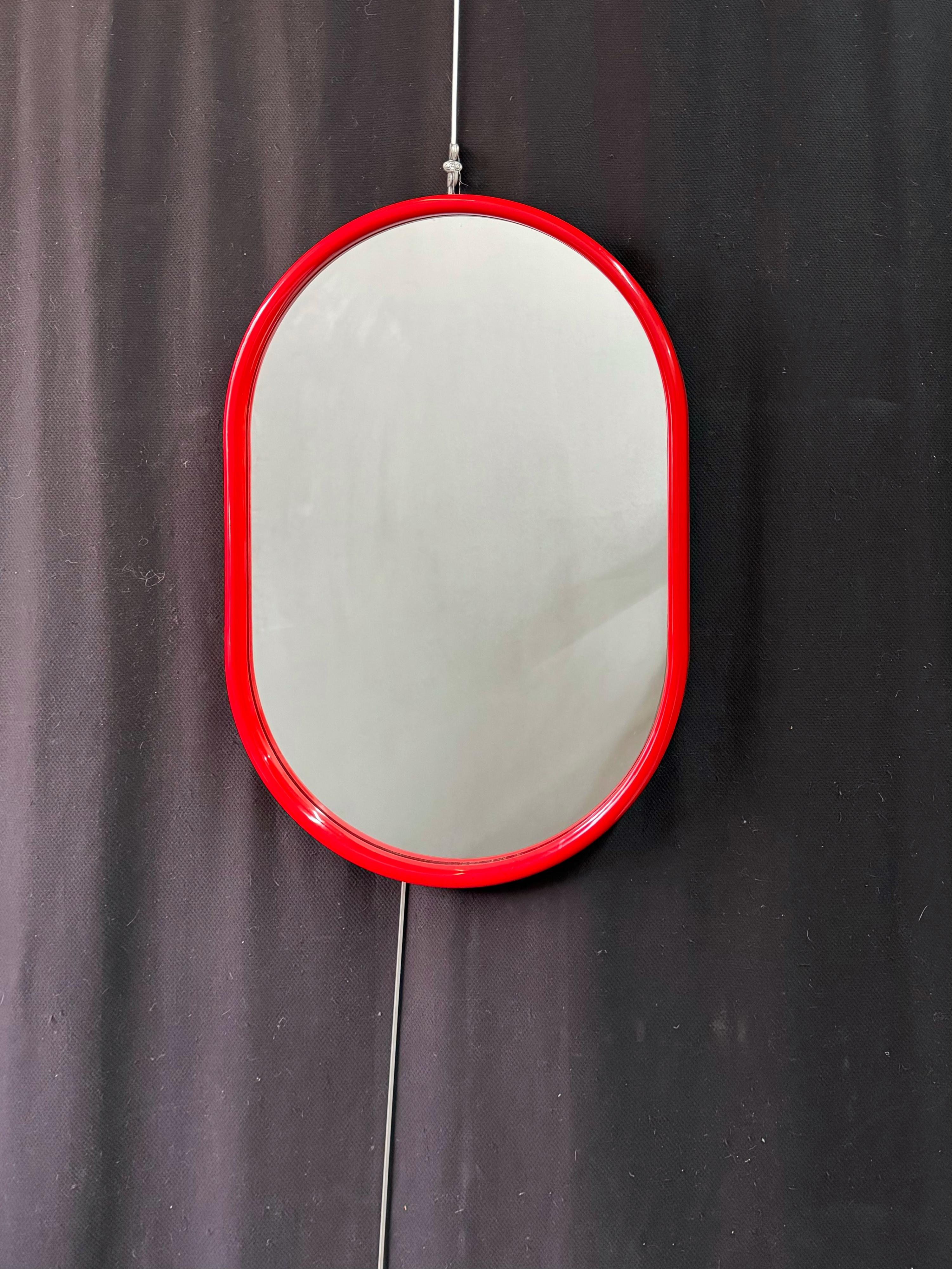 Italian 1960’s Mid Mod wall mirror with a bright red curved acrylic frame in an oval silhouette. Perfect vanity mirror to reflect your style and make your space pop!

The mirror measures 31” tall x 22” wide x 1.5” deep. 
