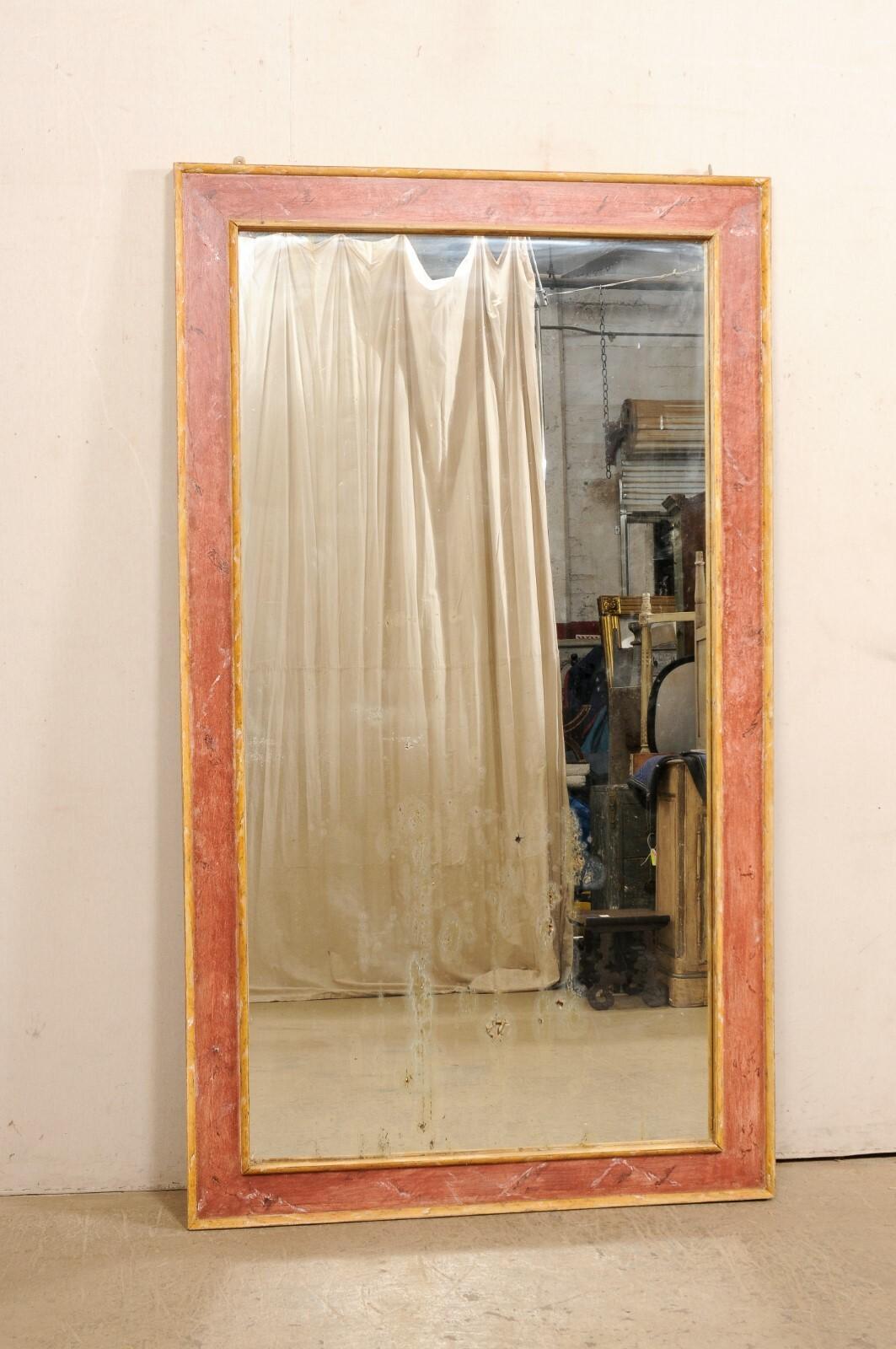 Miroir italien de grande taille, avec encadrement en bois peint, du 19e siècle. Ce grand miroir ancien d'Italie est de forme rectangulaire, avec un entourage en bois aux lignes épurées, encadrant le verre au centre. La finition est une nuance de