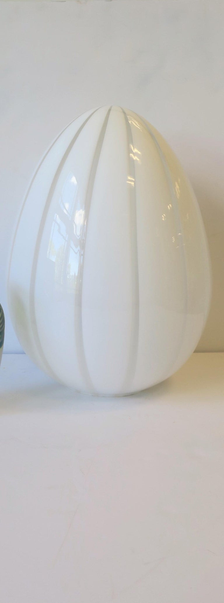 A beautiful Italian '70s Modern 'Vetri' Murano white and translucent art glass 'egg' table lamp, Italy, 1970s. Lamp is on a 'dimmer' switch offering various levels of light as show in image #12. Lamp is illuminated in images #4 and #10.

Lamp