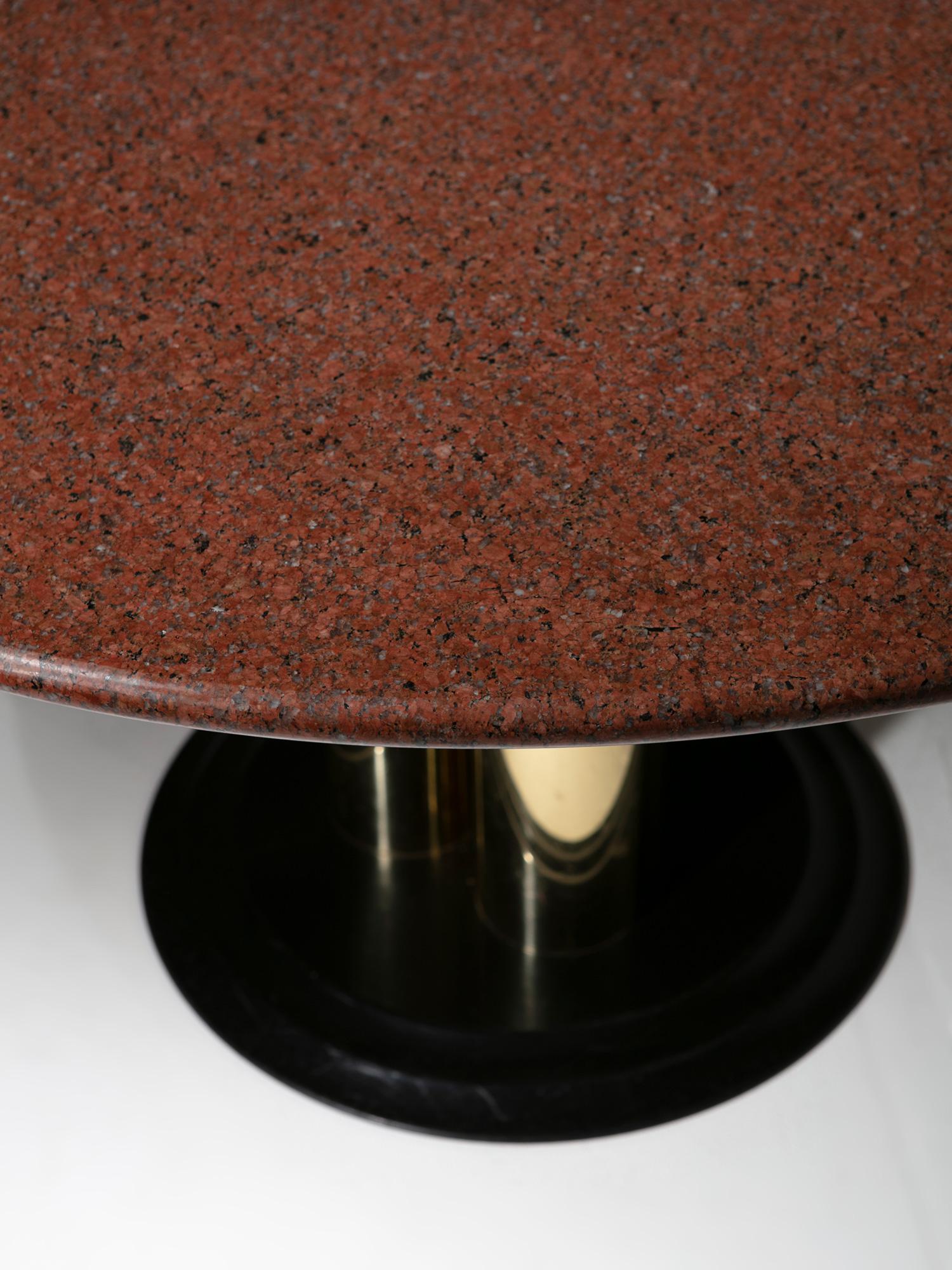 Red Marble top supported by three gold plated columns.