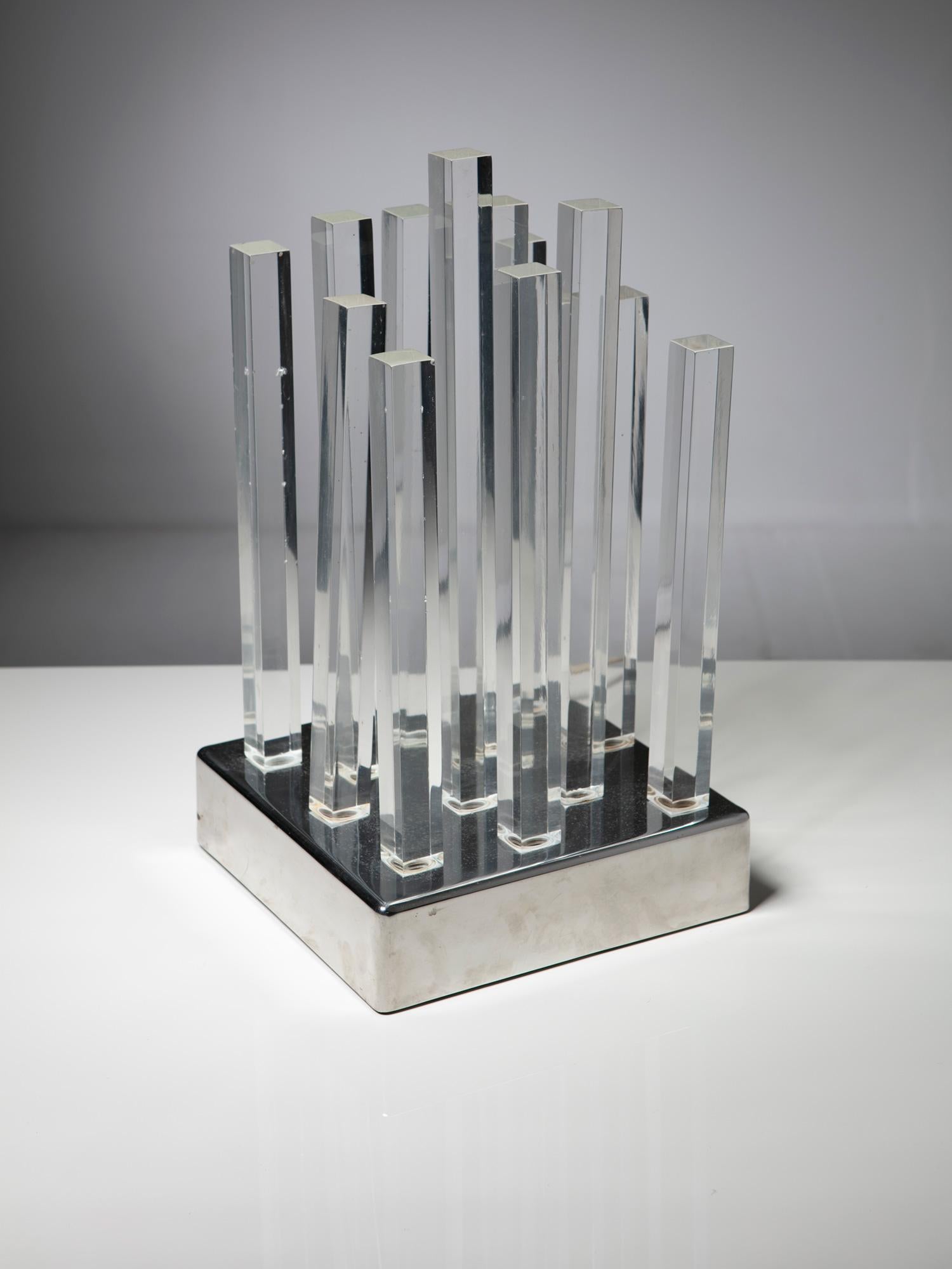 Rare table lamp manufactured by Cidue.
Large steel base supports 12 solid plexiglass blocks, transmitting the light from the bottom till the top of them.
This piece is part of the adventurous research made in Italian lighting design in the late