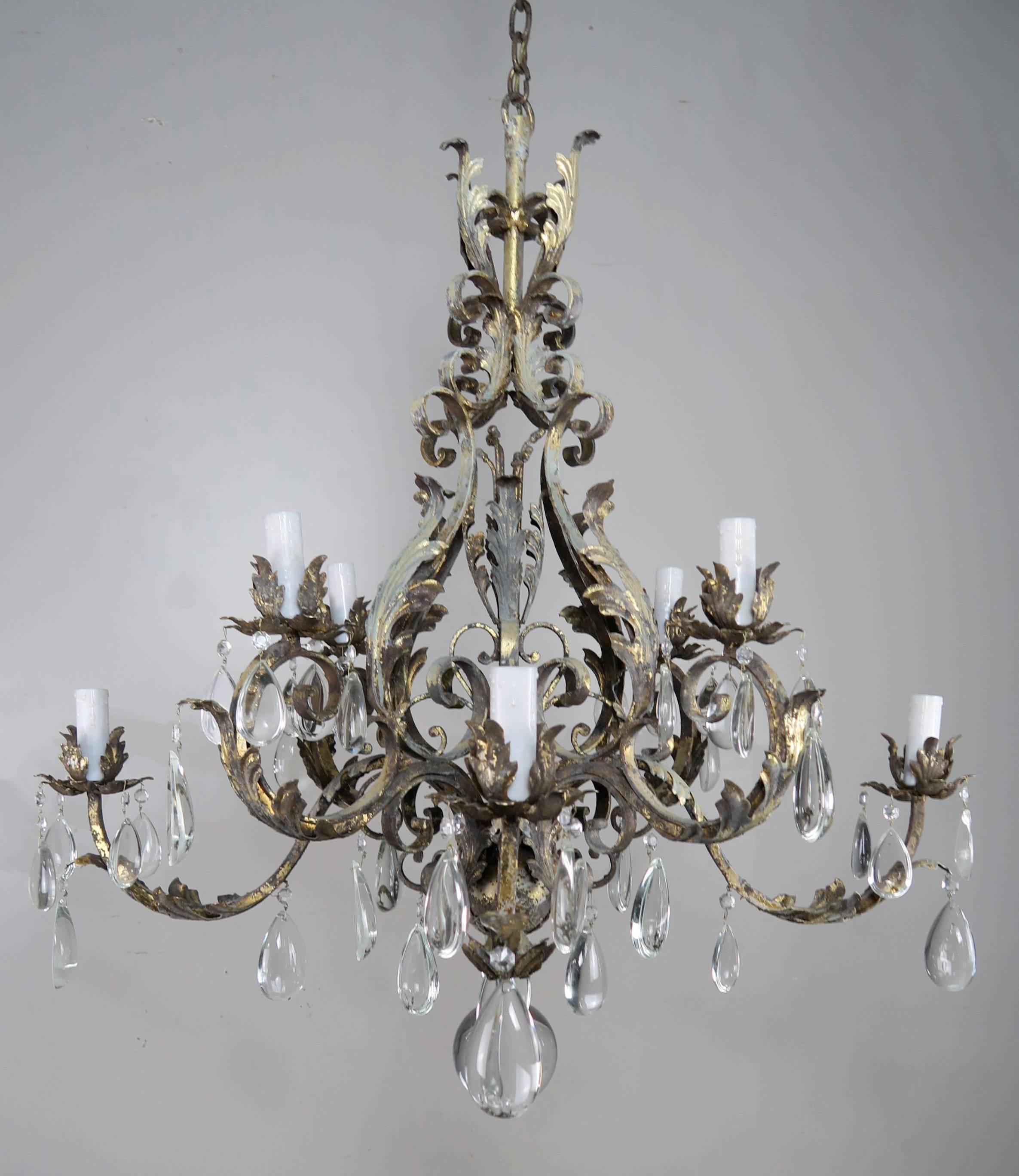 Italian eight-light wrought iron painted and gold leaf crystal chandelier. The chandelier is newly rewired with drip wax candle covers and includes chain and canopy.