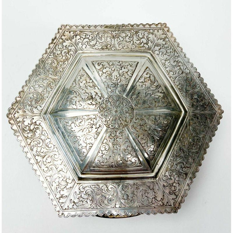 Italian 800 silver hexagonal large table box ribbed sides floral decoration, 1940.

Italian 800 silver hexagonal large table box circa 1940. Ornate chased floral and foliate decoration to the hinged lid and sides. Ribbed pattern to the sides, rich