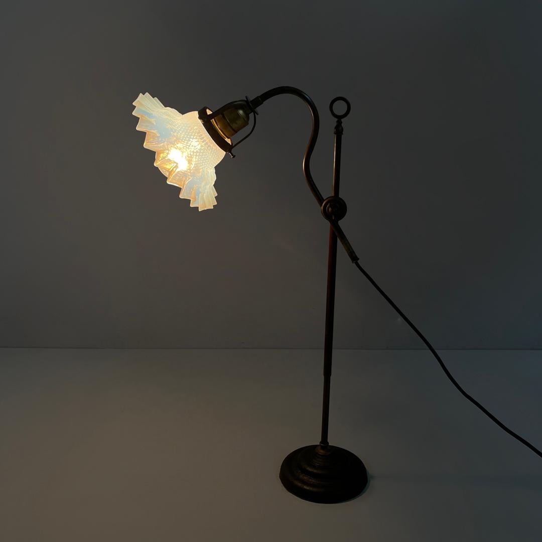 Italian adjustable brass and glass table lamp with ceramic switch, early 1900s
Round base table lamp. The lampshade is made of transparent glass with light blue shades, the part attached to the dome-shaped structure with a geometric pattern which