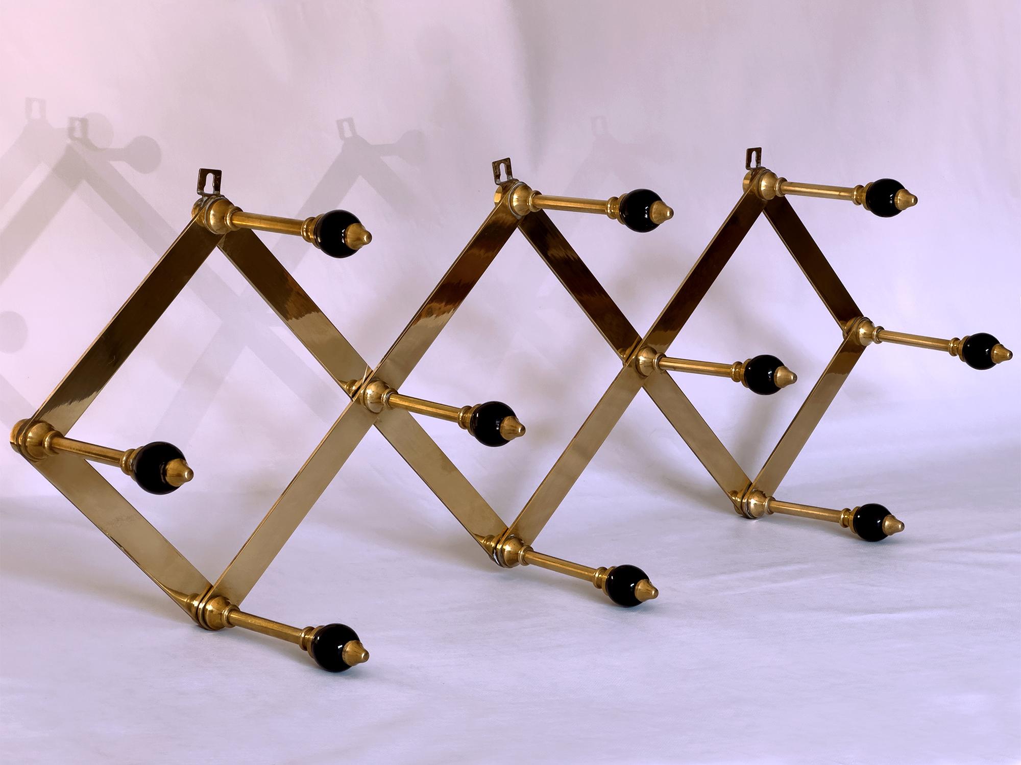 Stunning Italian Coat Hanger of the 1950s, model 'At4 Fisarmonica', well designed by Arch. Luigi Caccia Dominioni for Azucena.
Its structure is adjustable in length and is made of brass with black lacquered wooden knobs.
The dimensions are variable,