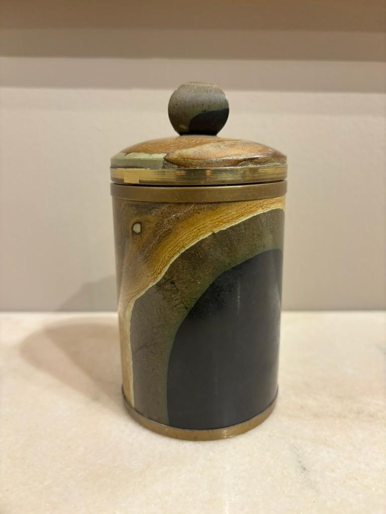 Italian 1970's carved and polished agate cylindrical box with brass molding. The top knob carved in cushion form. The stone is just beautiful, you can get lost gazing into this small object that holds multitudes. A singular object of contemplation,