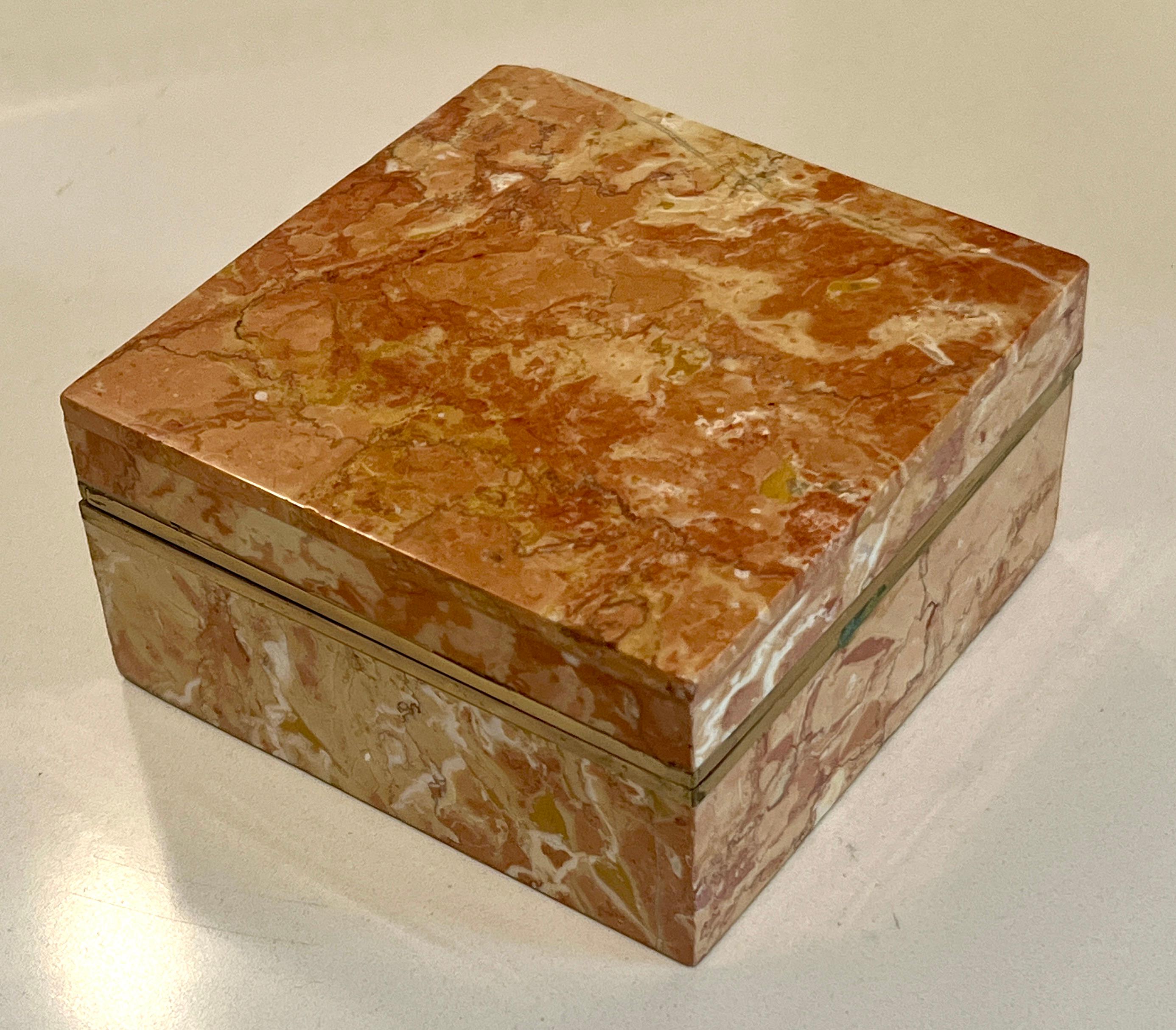 Square Alabaster box with brass banding at closure.  The lid is not hinged but pulls completely off to reveal a brown velvet interior.   The Amber or Gold color alabaster is a wonderful color.

A compliment to any cocktail table, bedside or side